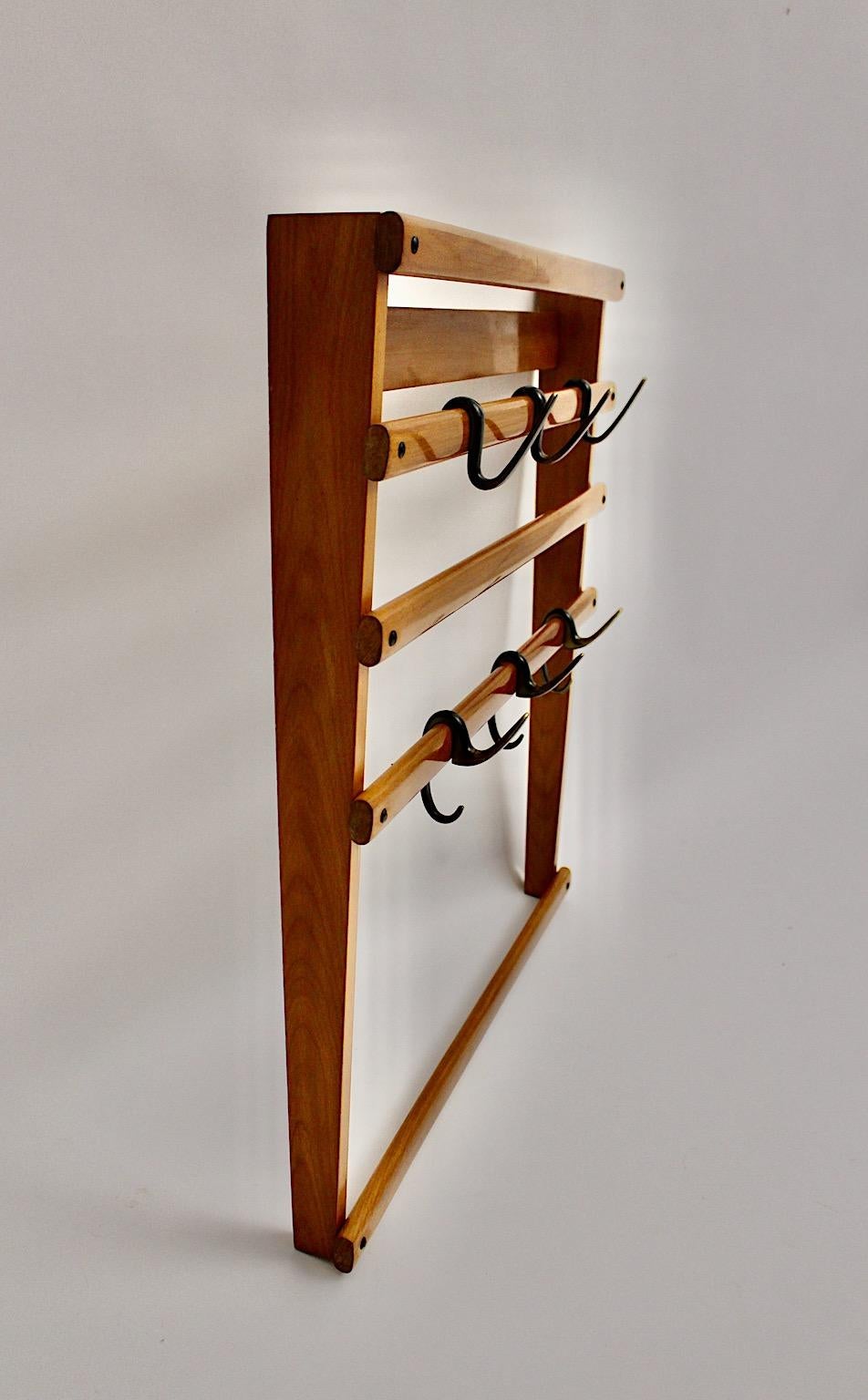 An original Carl Auböck vintage beech brass coat rack or wall mounted wardrobe, which was designed in Austria 1950s.
The coat rack was made of shellac polished beech wooden slats and features six slightly curved partly black patinated brass hooks in