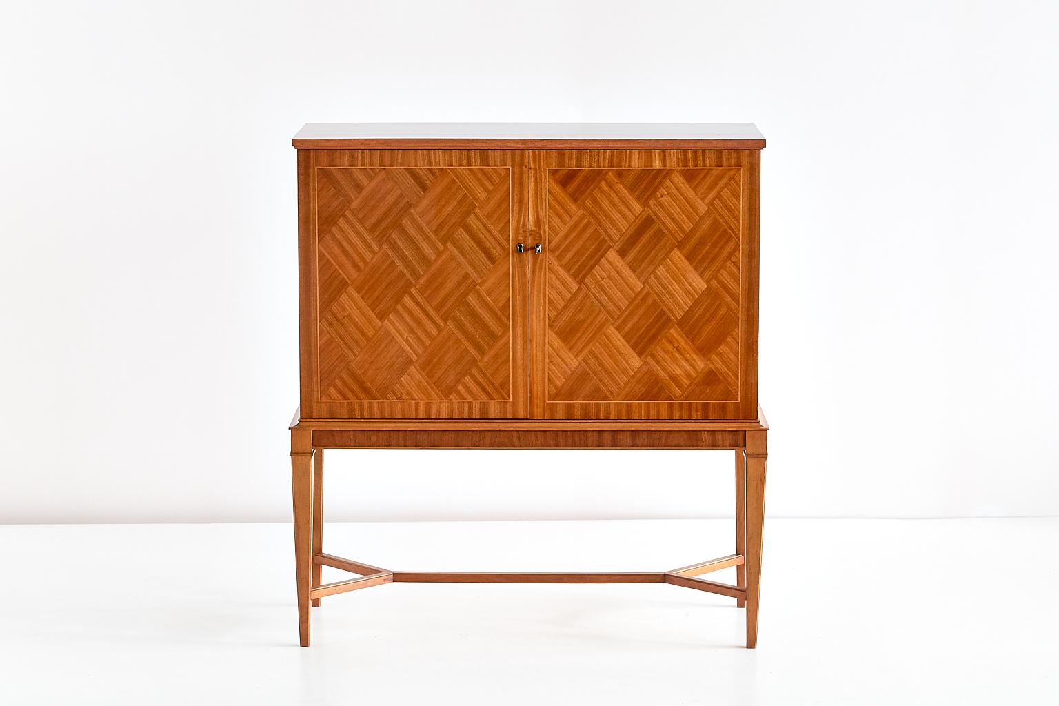 This elegant bar cabinet was manufactured by the Svenska Möbelfabrikerna in Bodafors in the late 1940s. The design is attributed to the Swedish designer and architect Carl-Axel Acking. The double doors feature a striking geometric pattern in a