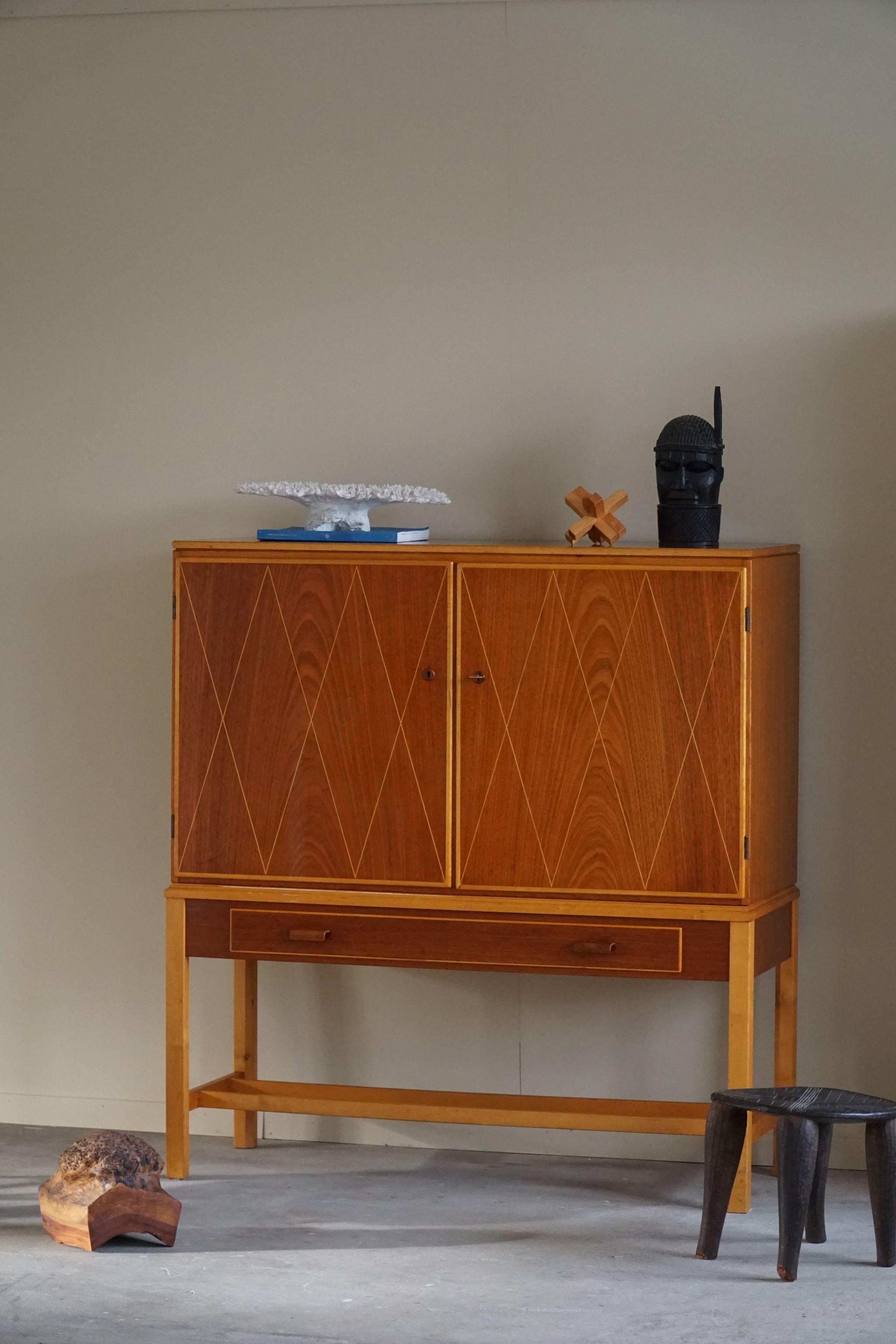 Rare cabinet with highlighted details, made in teak and birch. Designed by Carl-Axel Acking for Nordiska Kompaniet, Sweden 1950s. 

A fine mid century vintage piece that pair well with many types of interior styles. A Modern, Scandinavian, Classic
