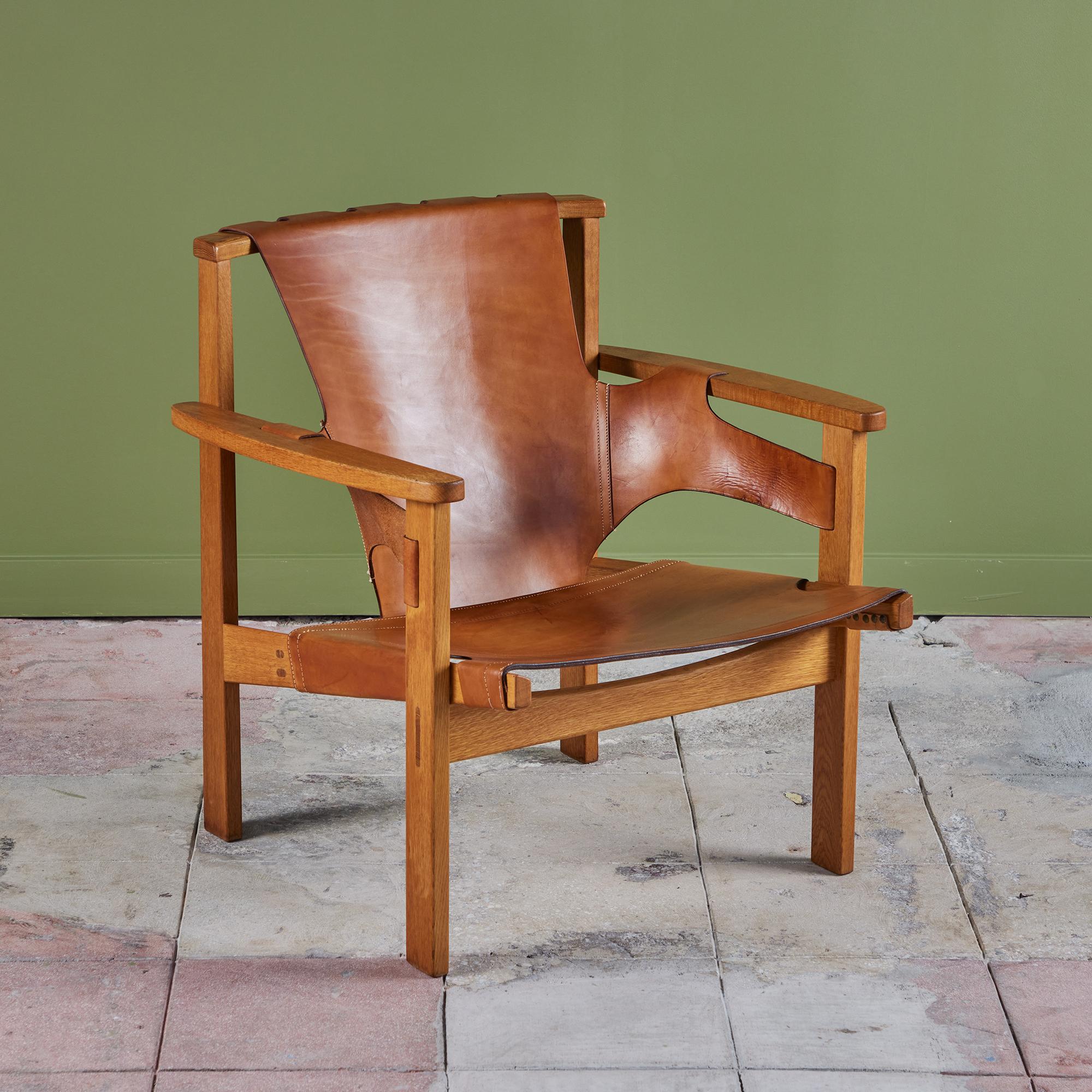 Lounge chair by Carl-Axel Acking for Nordiska Kompaniet, c.1950s, Sweden. The chair was first debuted at the Triennial exhibition in Milan, hence the chairs name. The cognac leather lounge chair is wrapped around an oak frame and finished with both