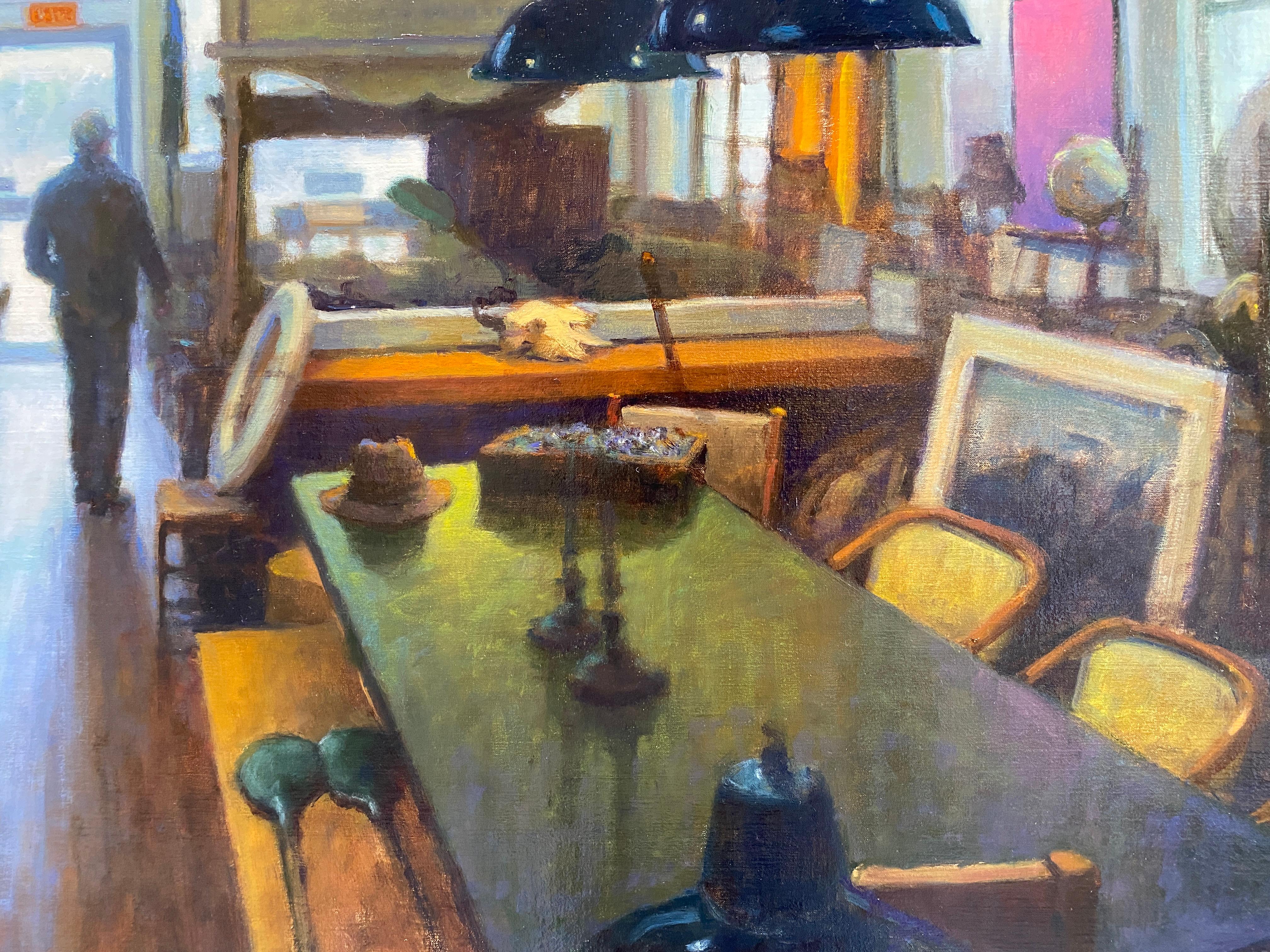 An oil painting, set inside the popular Sag Harbor Antique Shop, Black Swan Antiques. A figure stands against the natural light from the doorway, amidst the various objects for sale. An old ship hangs from the ceiling, along with industrial light
