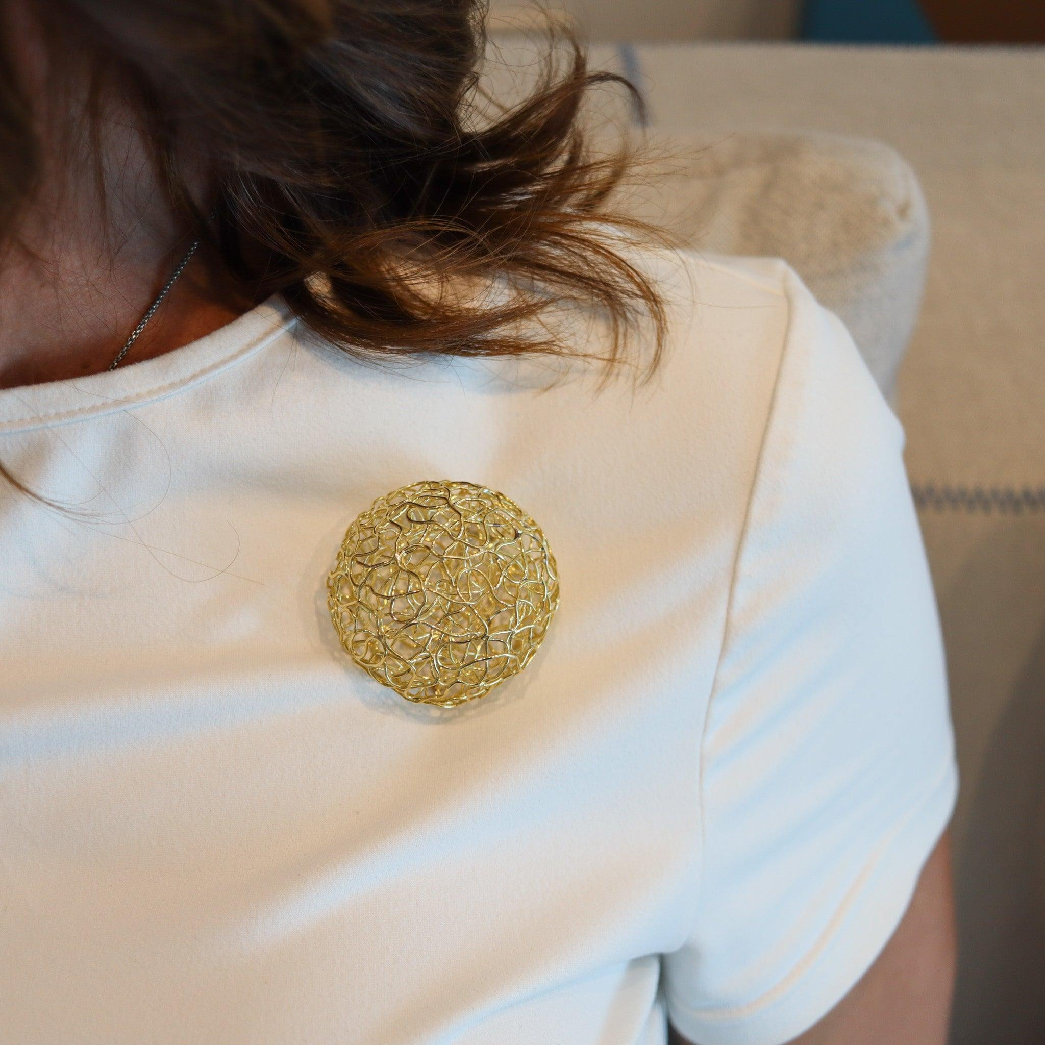 A pendant-brooch designed by Carl Bucherer.

This is an amazing three-dimensional pendant-brooch created in Switzerland by the house of Carl Bucherer, back in the 1970. The piece has been masterfully crafted as a nest made-up with an infinite