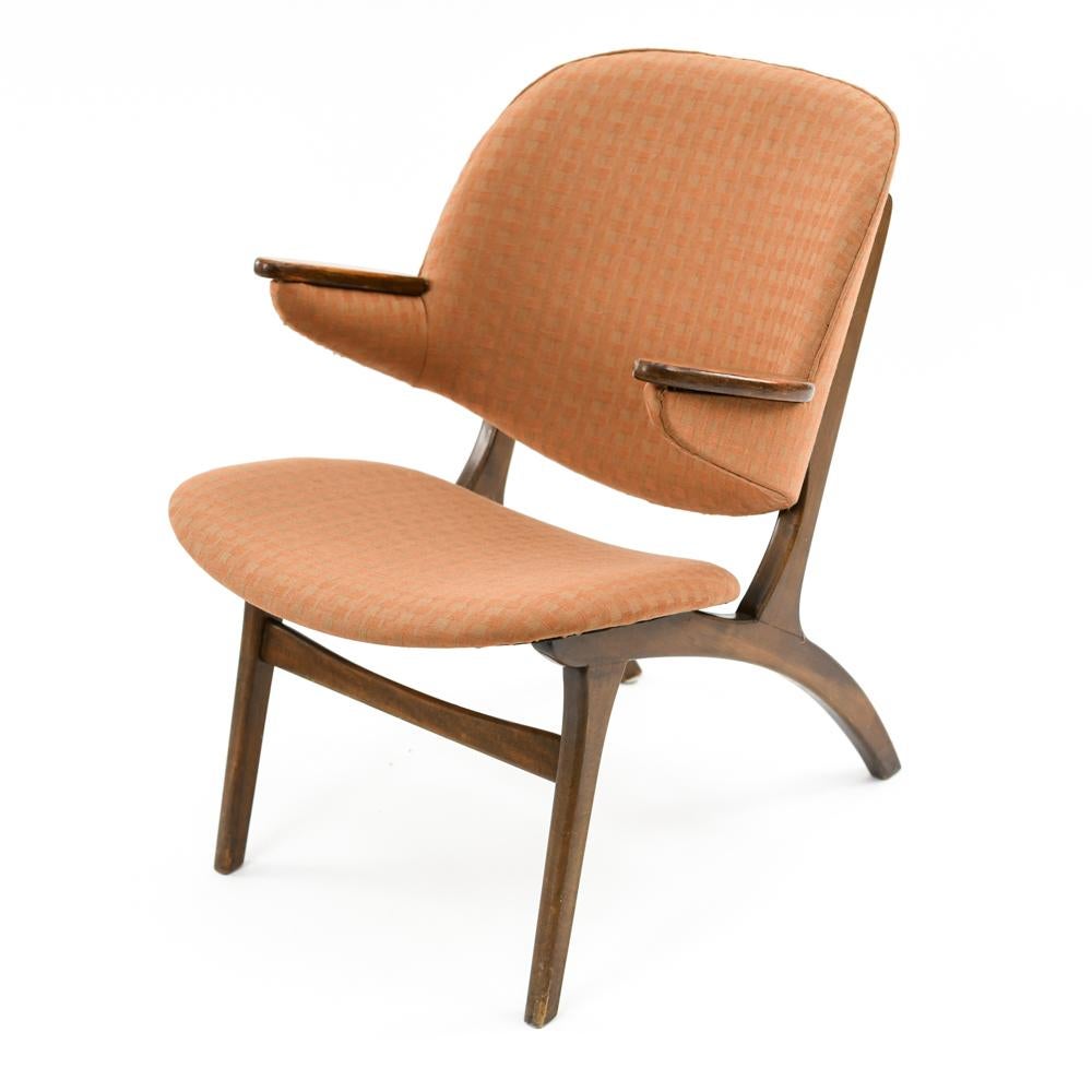 This Danish midcentury armchair was designed by Carl Edward Matthes in the 1950s and manufactured by N.A. Jorgensen. Similar to the rare model 33, this chair features exposed wood armrests and a wooden base with an upholstered seat and backrest that