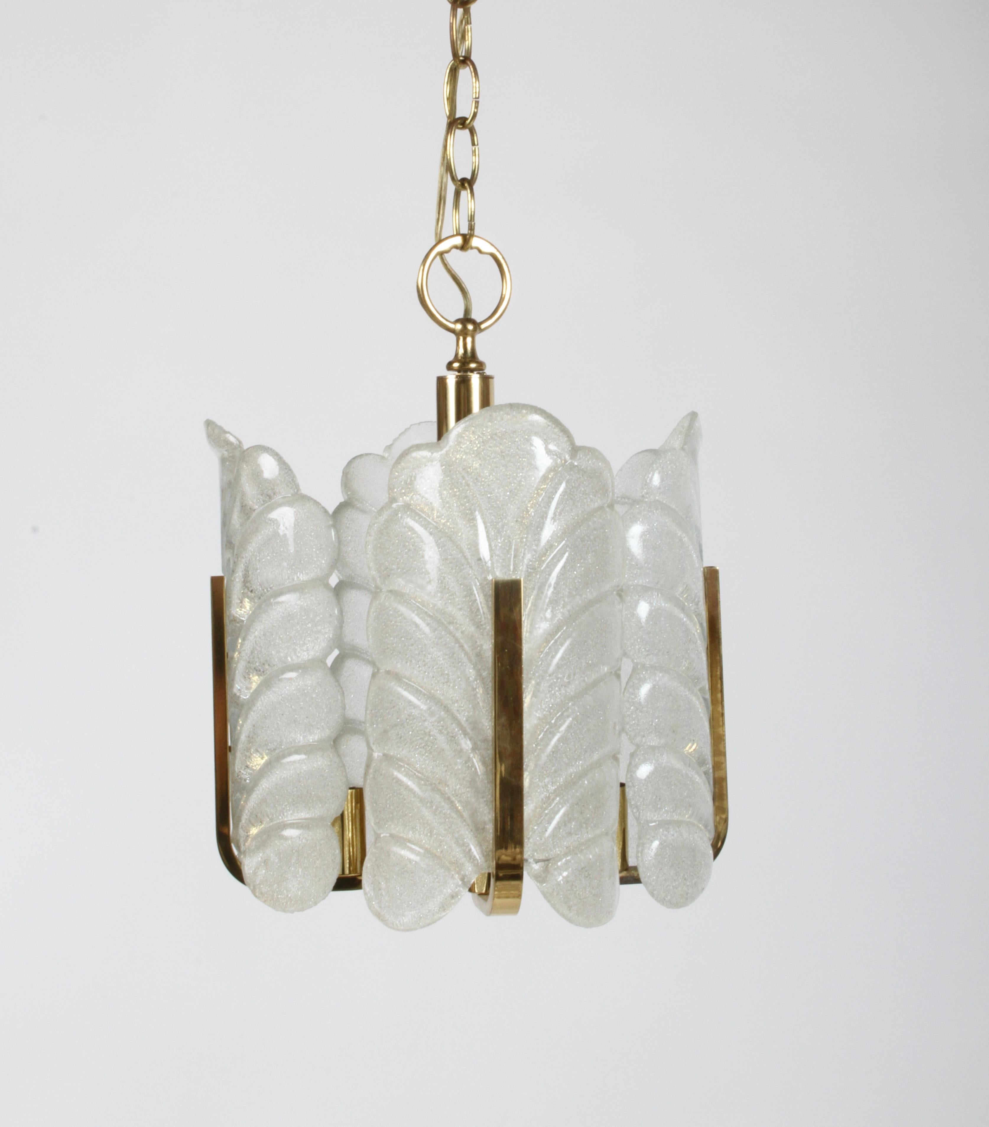 Lustre ou suspension Carl Fagerlund pour Orrefors Murano avec quatre feuilles en forme d'acanthe en verre de Murano texturé transparent, avec cadre en laiton, support central et chaîne. Accepte quatre ampoules de la taille d'une bougie. Avec chaîne