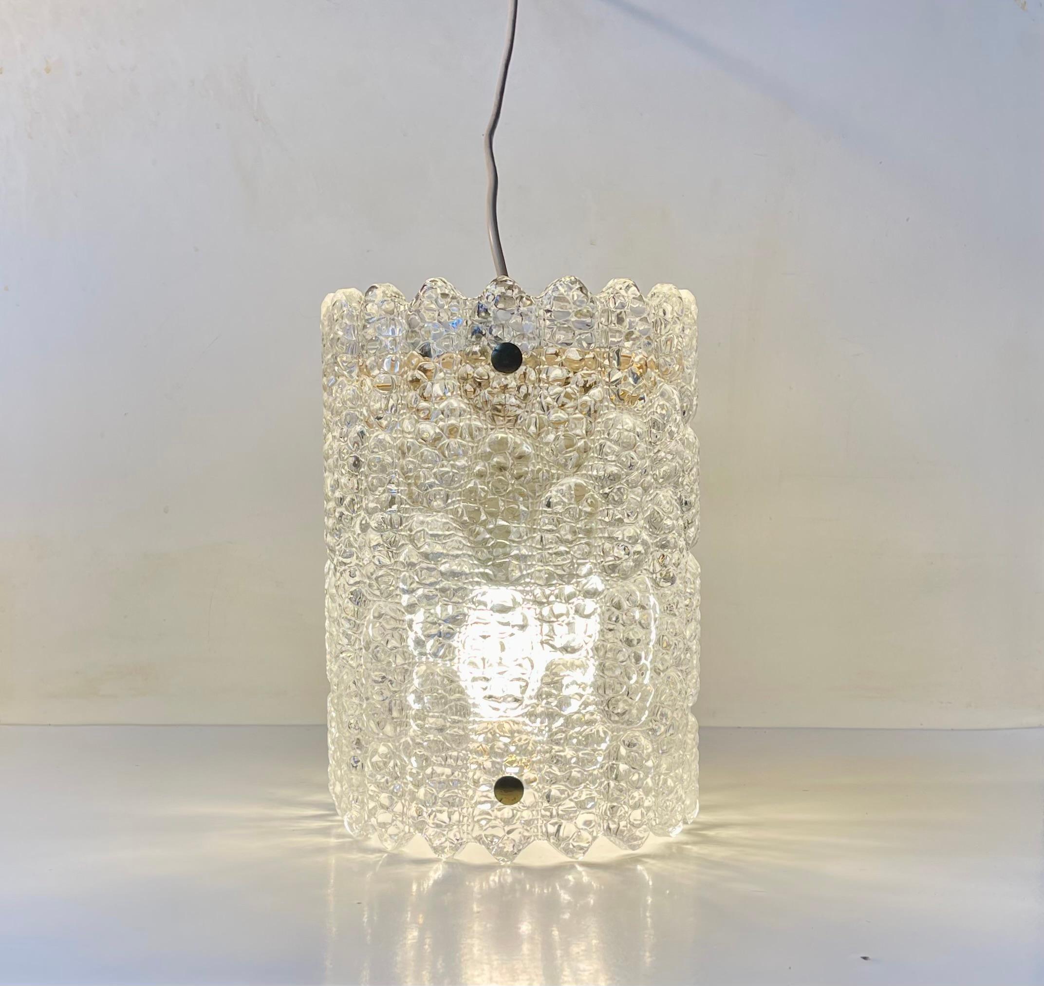 Cylindrical crystal and brass pendant lamp designed by Carl Fagerlund and manufactured by Orrefors in Sweden during the early 1960s. It features its original removable brass plate to the top. Depending on the balance you want between up/down