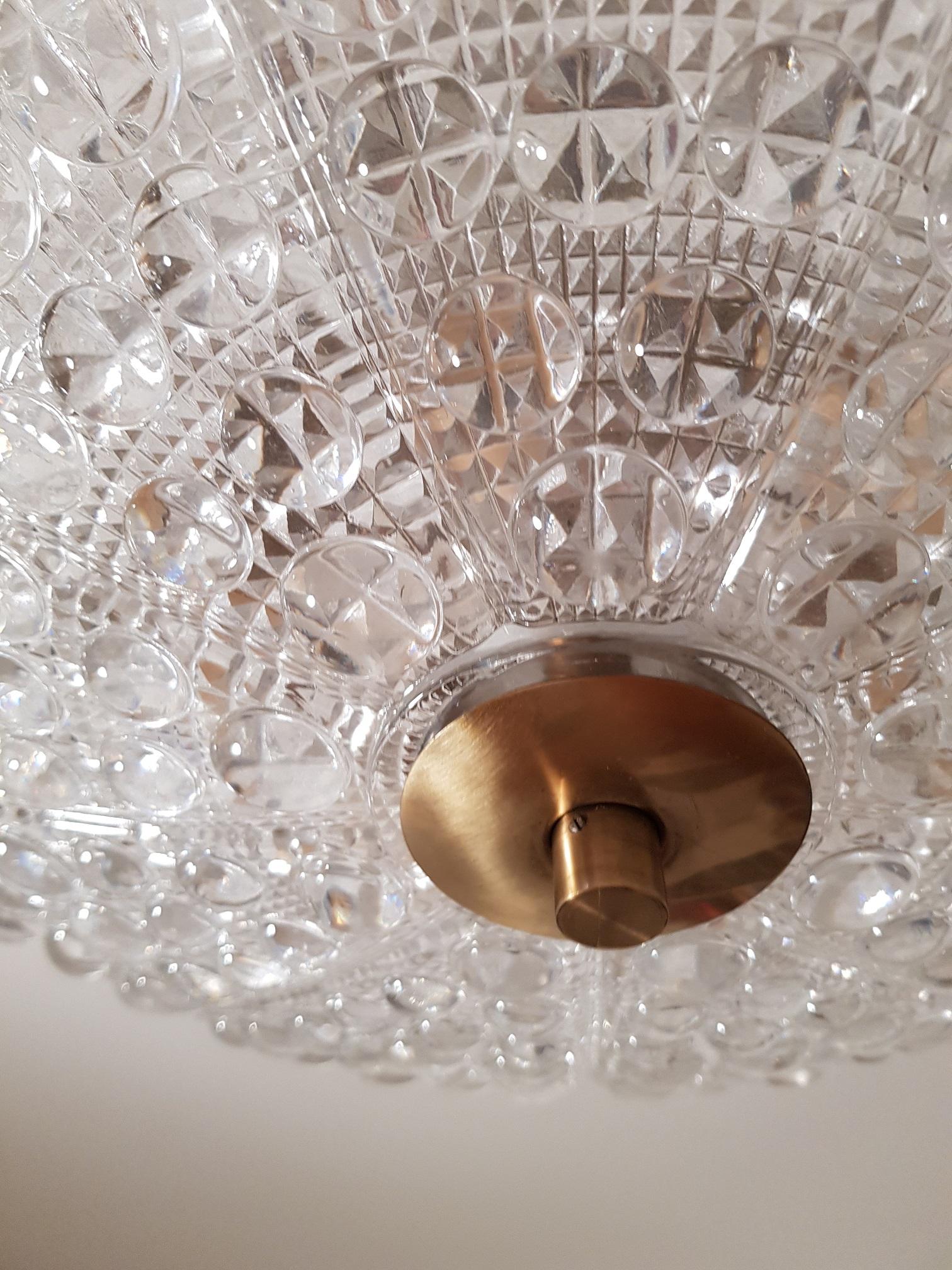 Vintage dual disc ceiling lamp/chandelier in brass and crystal glass from Orrefors in Sweden. Produced in the 1960s by Swedish Orrefors. Scandinavian Modern design with the traditional brass and glass combination. Swedish Carl Fagerlund is famous