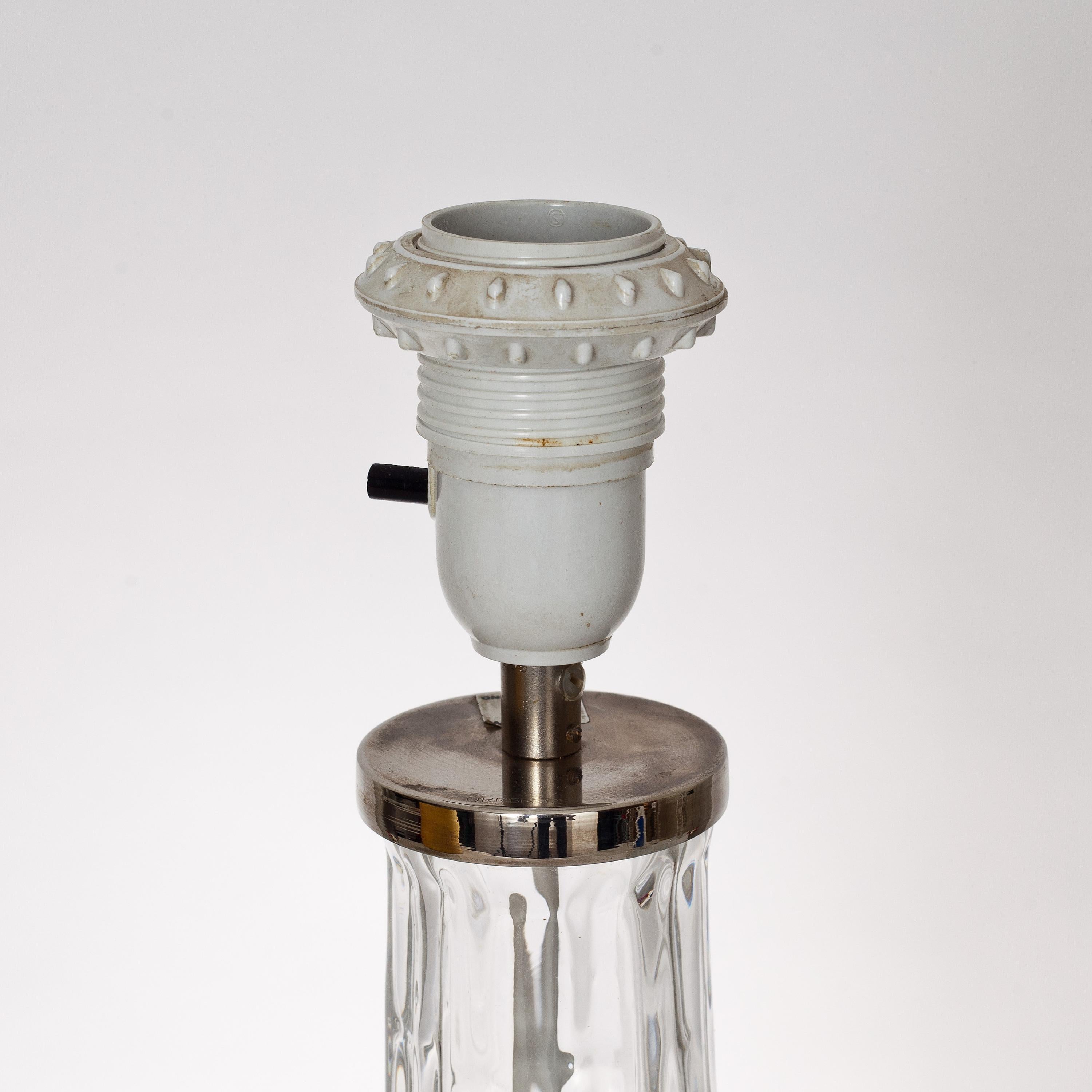 LAMPE DE TABLE conçue par Carl Fagerlund pour Orrefors. Milieu du 20e siècle.
Base de lampe en verre. Hauteur 38 y compris la base de la lampe. Avec une hauteur d'abat-jour de 66.
Électrification en bon état non testée