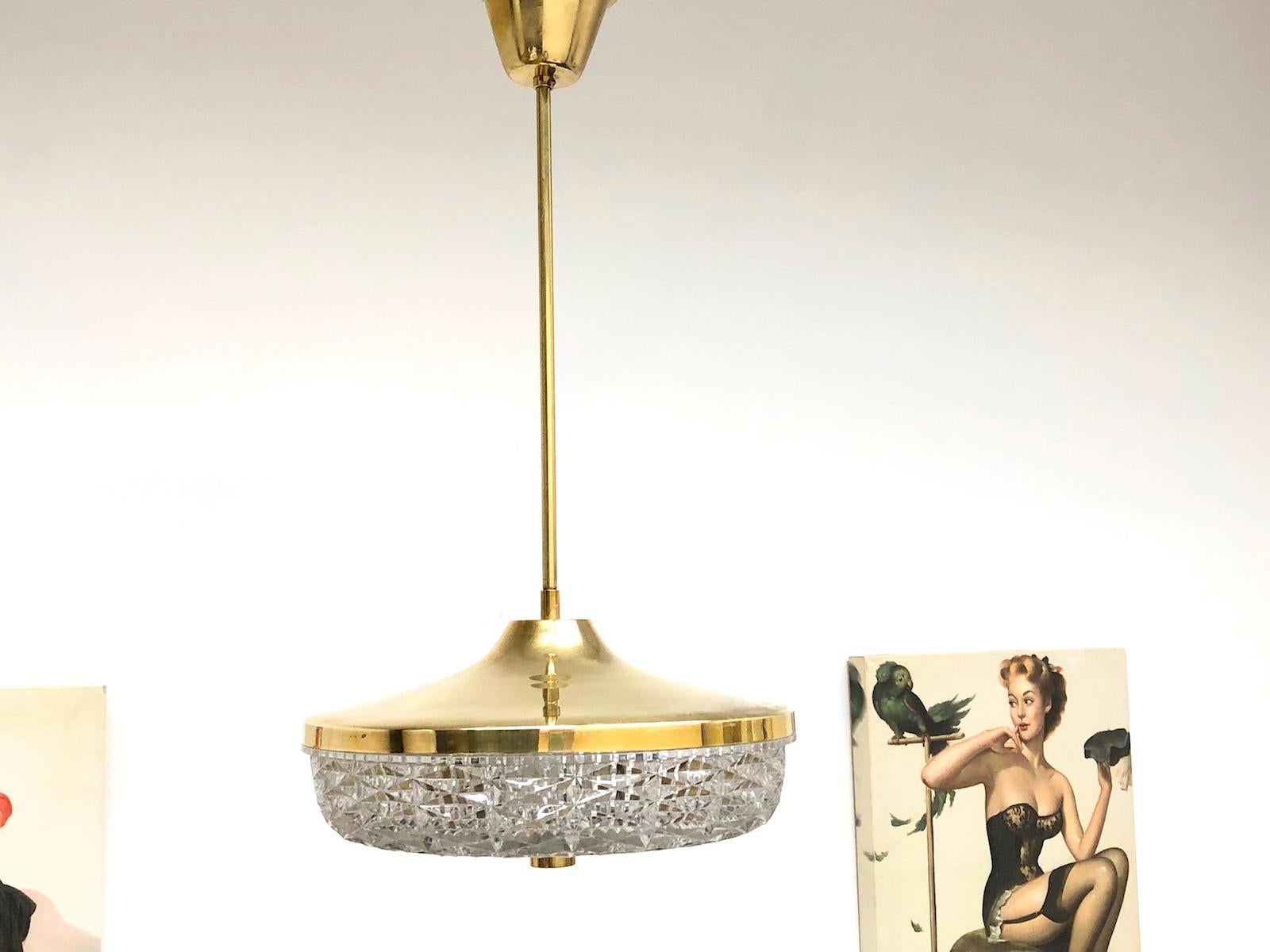 Beautiful crystal glass pendant light by Carl Fagerlund for Orrefors in the 1960s - gorgeous Scandinavian lamp with crystal glass and brass, in beautiful vintage condition. The chandelier requires four European E14 candelabra bulbs, each up to 40