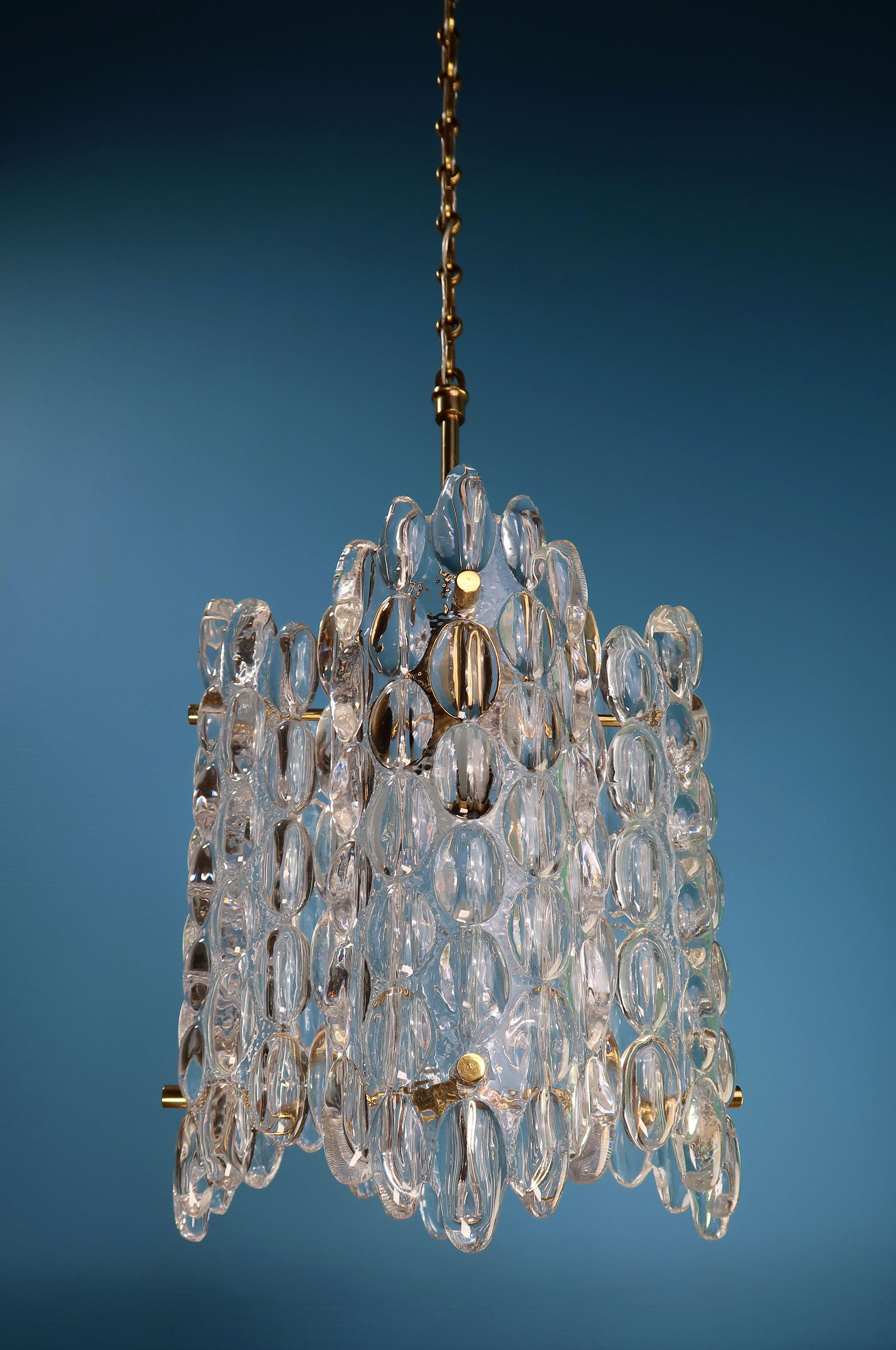 Iconic Swedish Mid-Century Modern crystal chandelier composed of four rounded and bubble textured crystal plates on polished brass mount and brass hardware. By Swedish designer Carl Fagerlund for Orrefors and manufactured in the 1950s. Model
