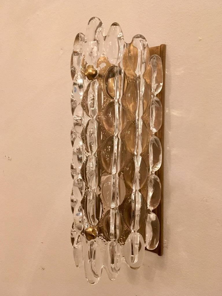 Pair of Scandinavian modern crystal sconces with an oval bubble effect on satin brass bachplate. Rewired for use in the USA.

Currently there are 2 pairs available, 3600 per pair