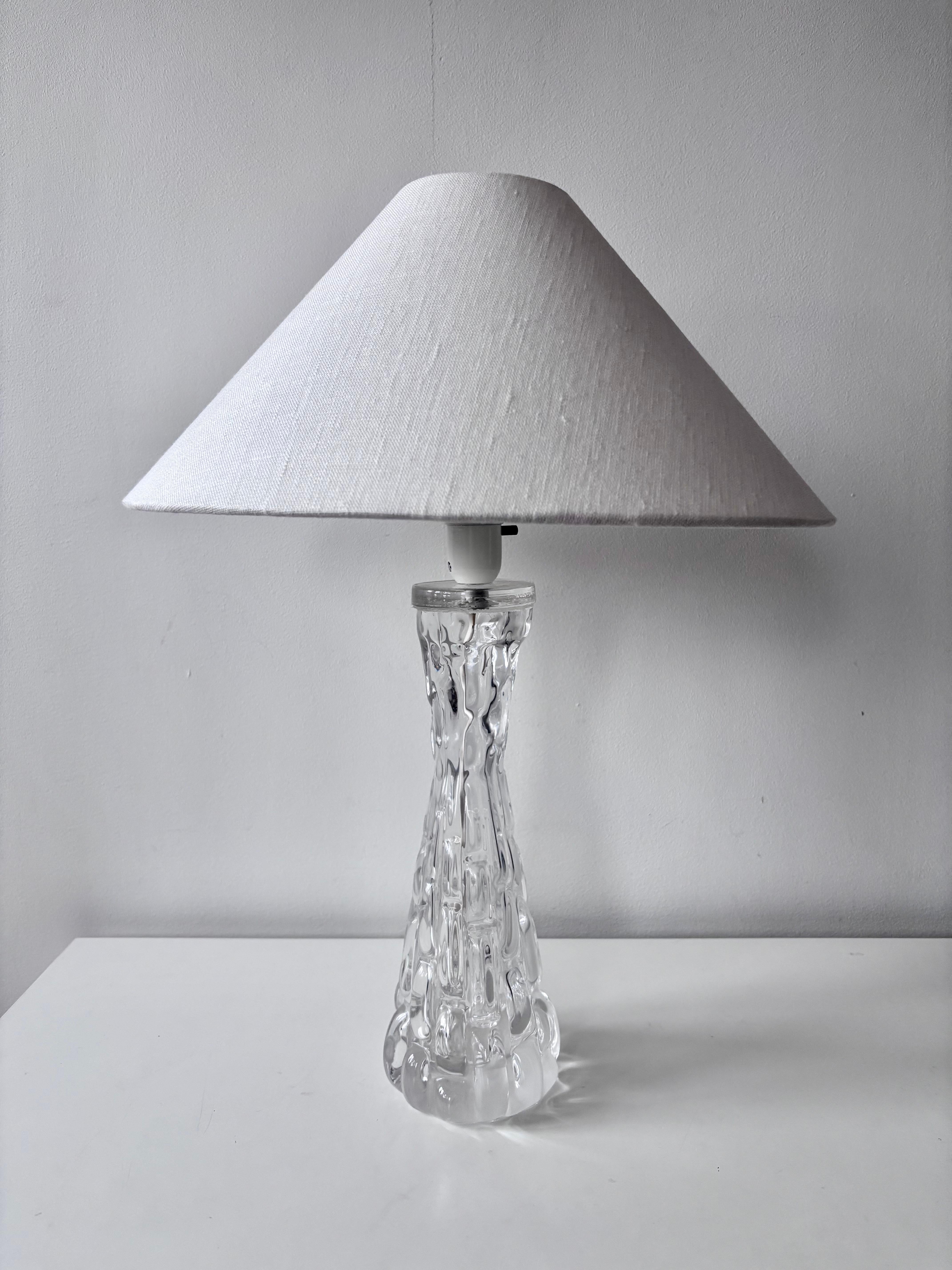 Exquise lampe de table en cristal conçue par Carl Fagerlund pour Orrefors, Suède, vers les années 1960. La lampe est dotée d'une base sculpturale en cristal coulé à la main avec une surface organique magnifiquement texturée - une marque de fabrique