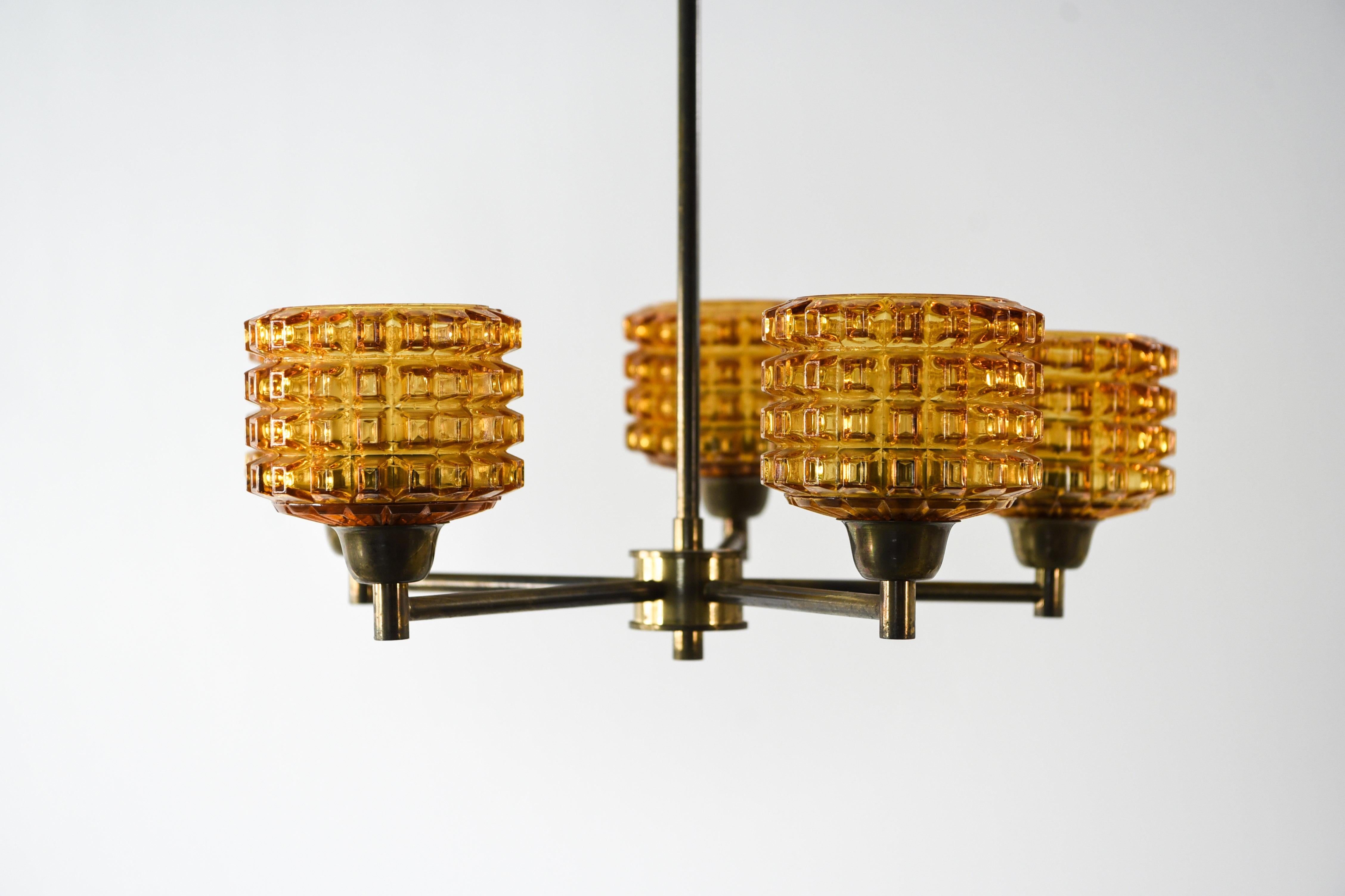 This five-arm Swedish midcentury chandelier was designed by Carl Fagerlund for Orrefors. This piece features a brass body with orange textures glass shades. This chandelier has a classic Fagerlund for Orrefors appearance with the fun detail of