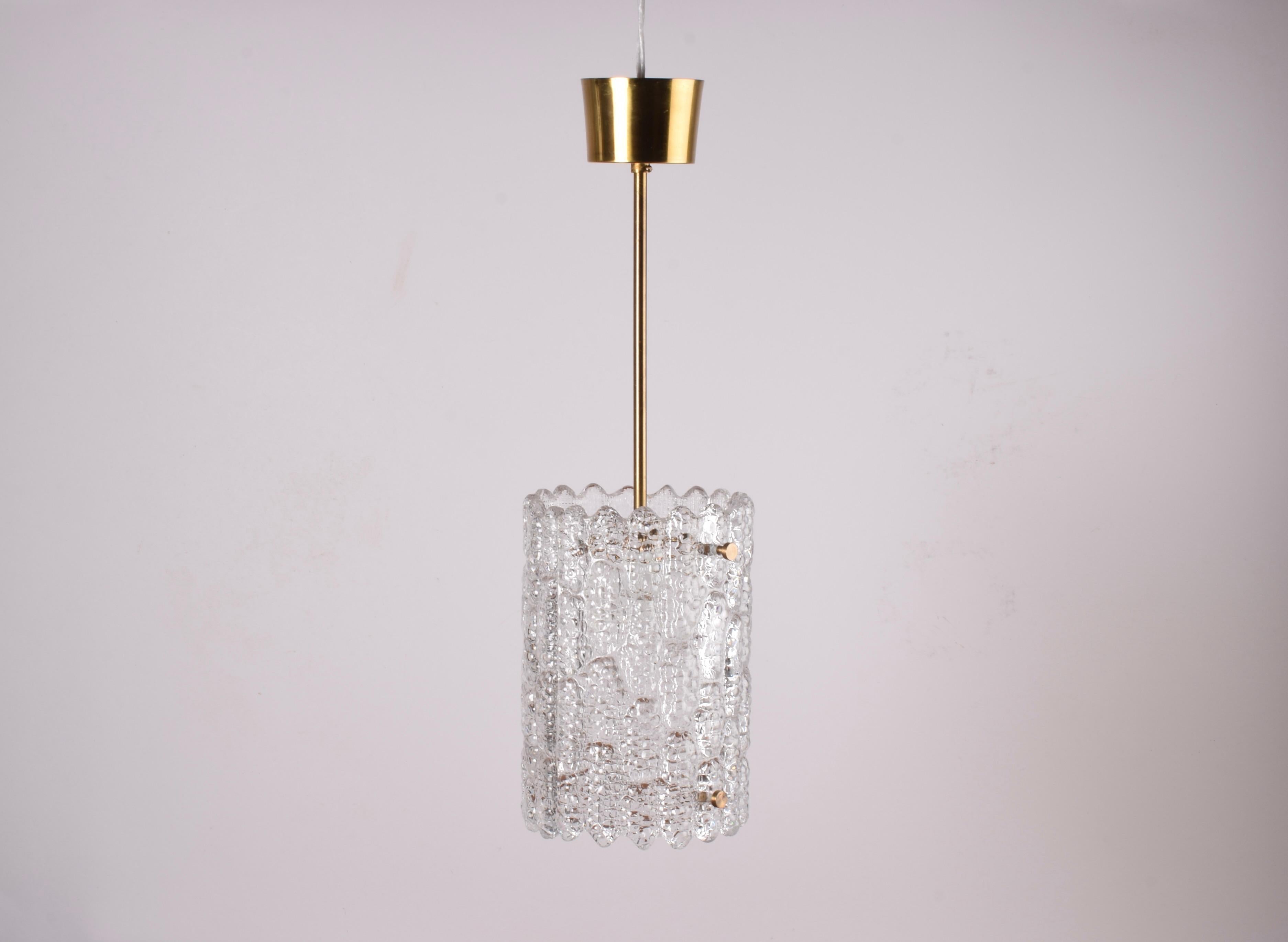 Vintage glass pendant by the Swedish designer Carl Fagerlund for Orrefors. Manufactured in the 1960s. 

The lamp is made of pressed translucent glass and has beautiful parts made from brass. The brass canopy is also included.

The lamps require E27