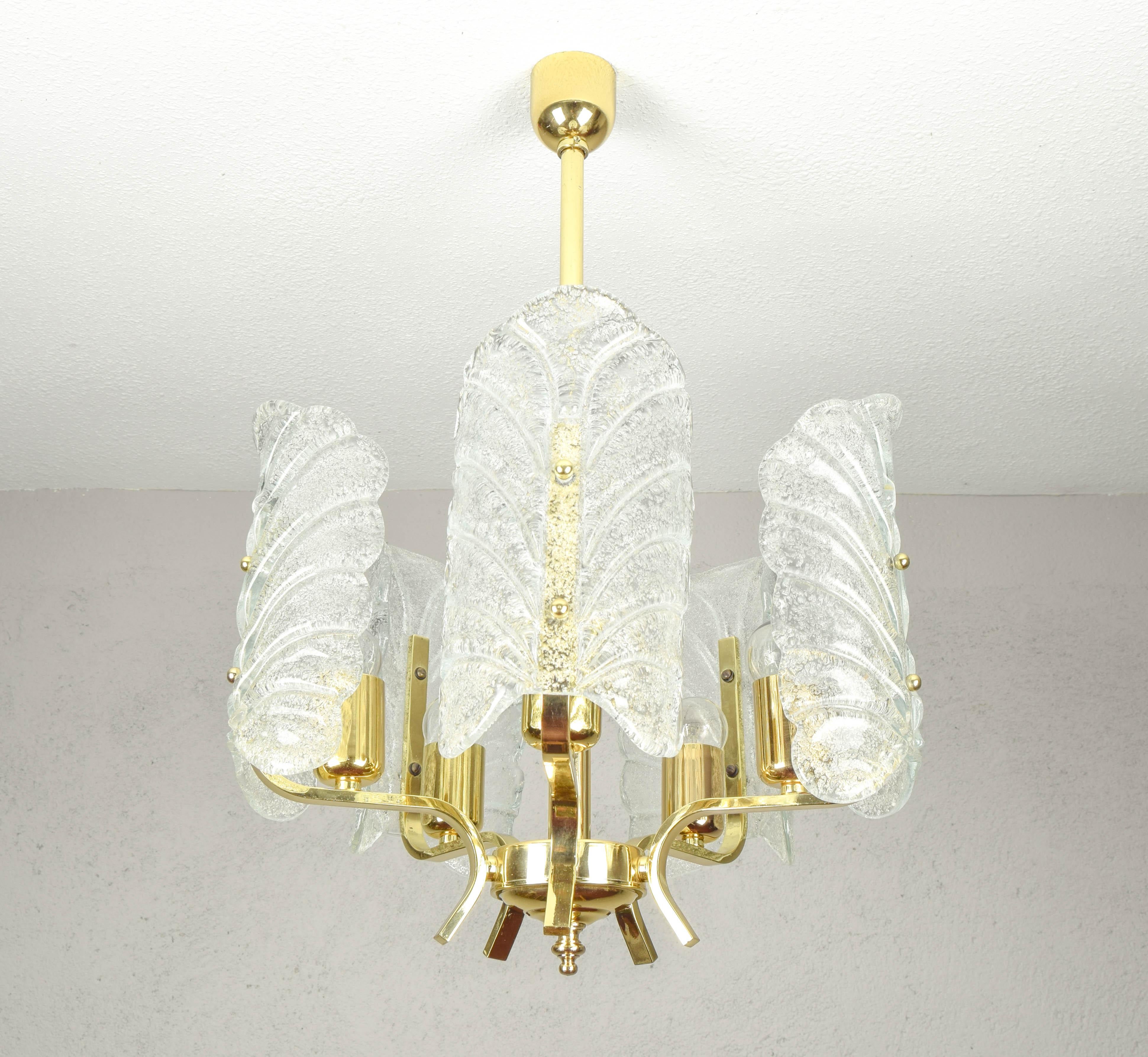 Carl Fagerlund chandelier for Orreford, Sweden.
Piece composed of a brass-plated steel body with five arms, five light points with an E27 socket and five sheets of acid-etched glass, which in turn contain tiny embedded crystals.
The condition of