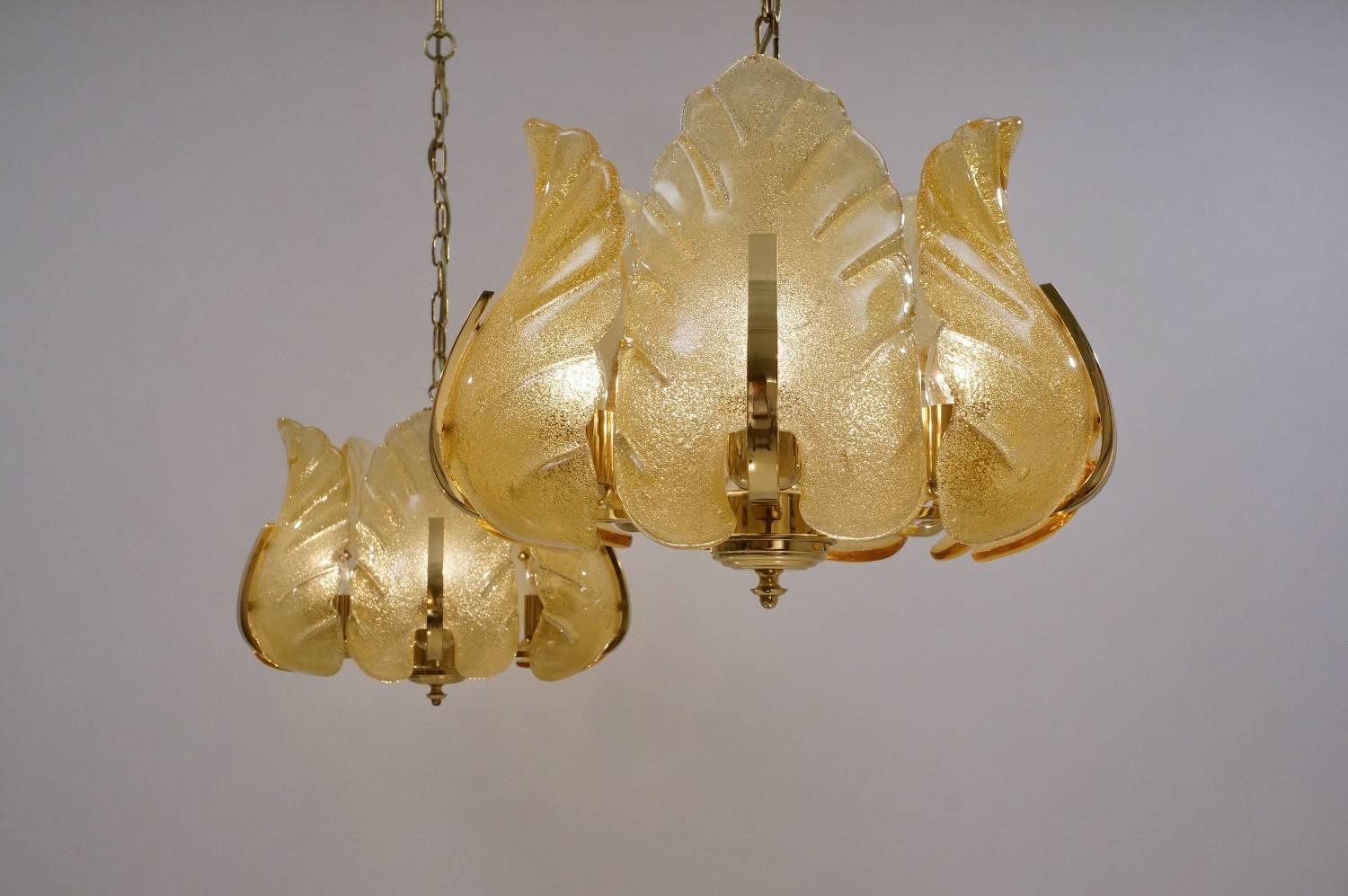 Carl Fagerlund Orrefors chandeliers, a matching pair, gold glass leaves on a brass frame, five lights, circa 1960s, Sweden.

This pair of chandeliers have been thoroughly cleaned respecting the vintage patina; both newly rewired and earthed, in