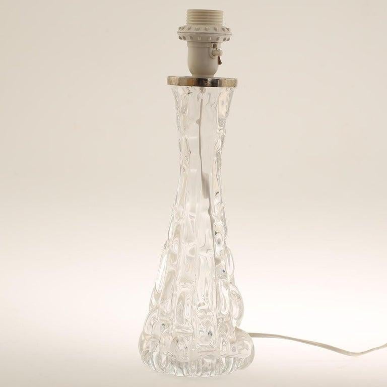 Orrefors, Carl Fagerlind pair of crystal glass table lamps. 1960's. 

An Orrefors crystal glass table lamp is a luxurious and artistic lighting piece, combining Orrefors' renowned craftsmanship in glassmaking with the elegance of functional lighting
