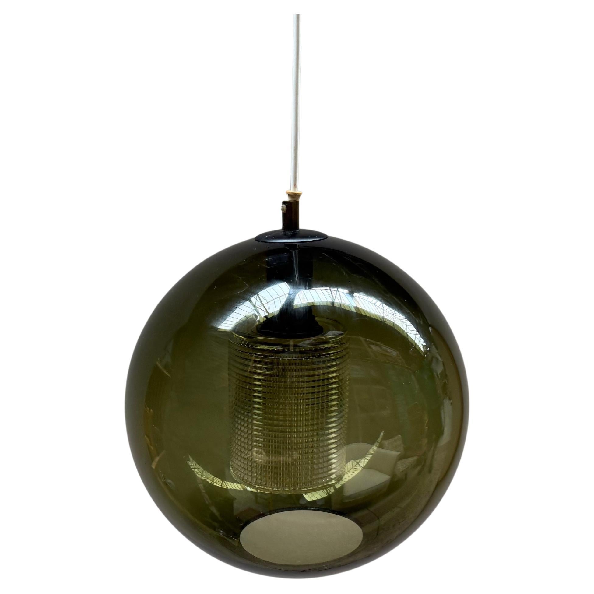 Elegante lampada a sospensione disegnata da Carl Fagerlund per l'azienda svedese Orrefors. La lampada è stata prodotta negli anni Sessanta.
Grande coppa cilindrica in vetro circondata da una coppa sferica in vetro verde.
Diametro e altezza circa 30