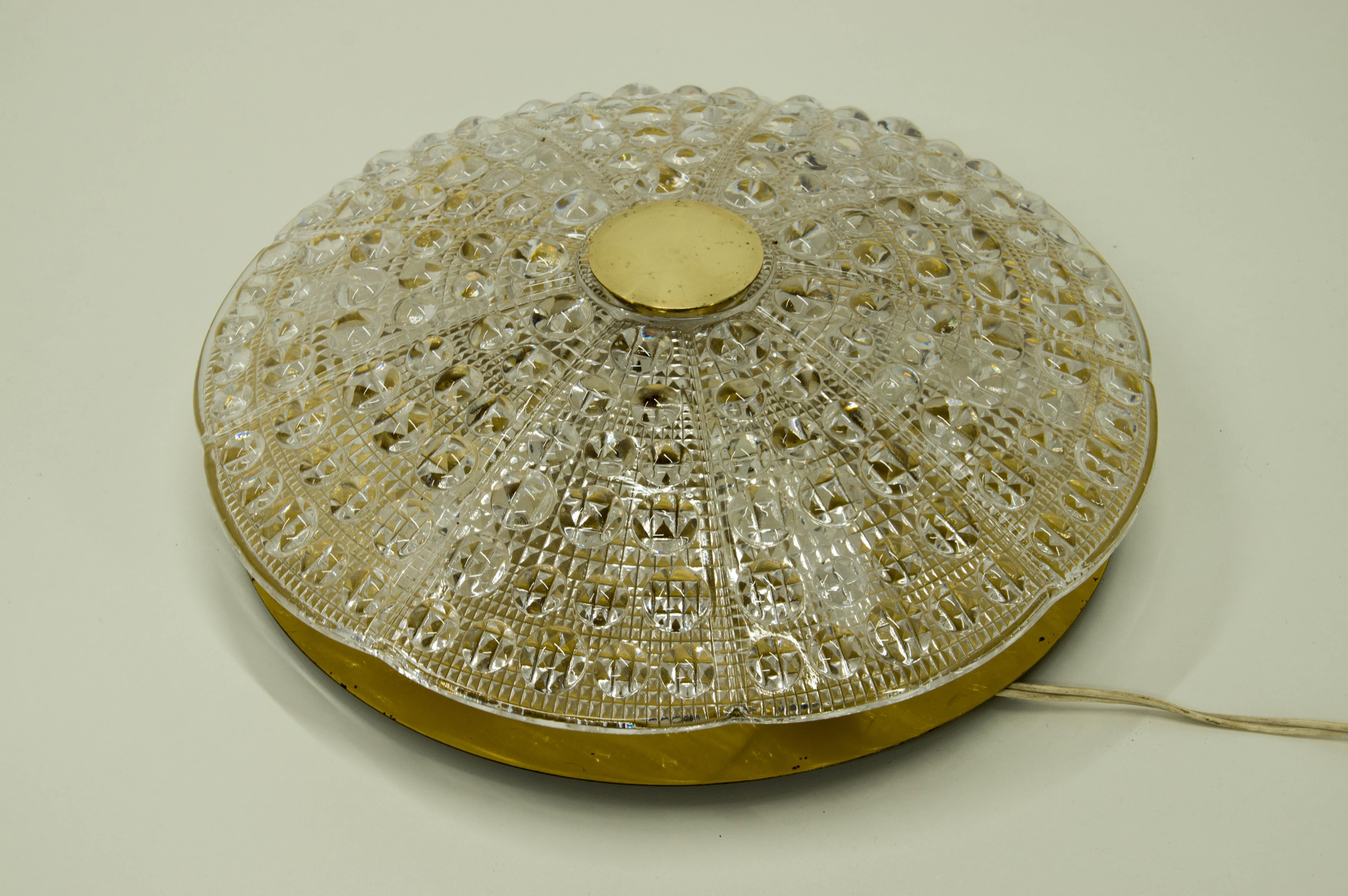 Carl Fagerlund's brass-mounted pressed glass diamond pattern flushmount ceiling fixtures designed for Lyfa. The fixture is fitted with six E14 bulbs, brass backplate and round brass mount on top. Very good condition, cleaned and repolished.


  