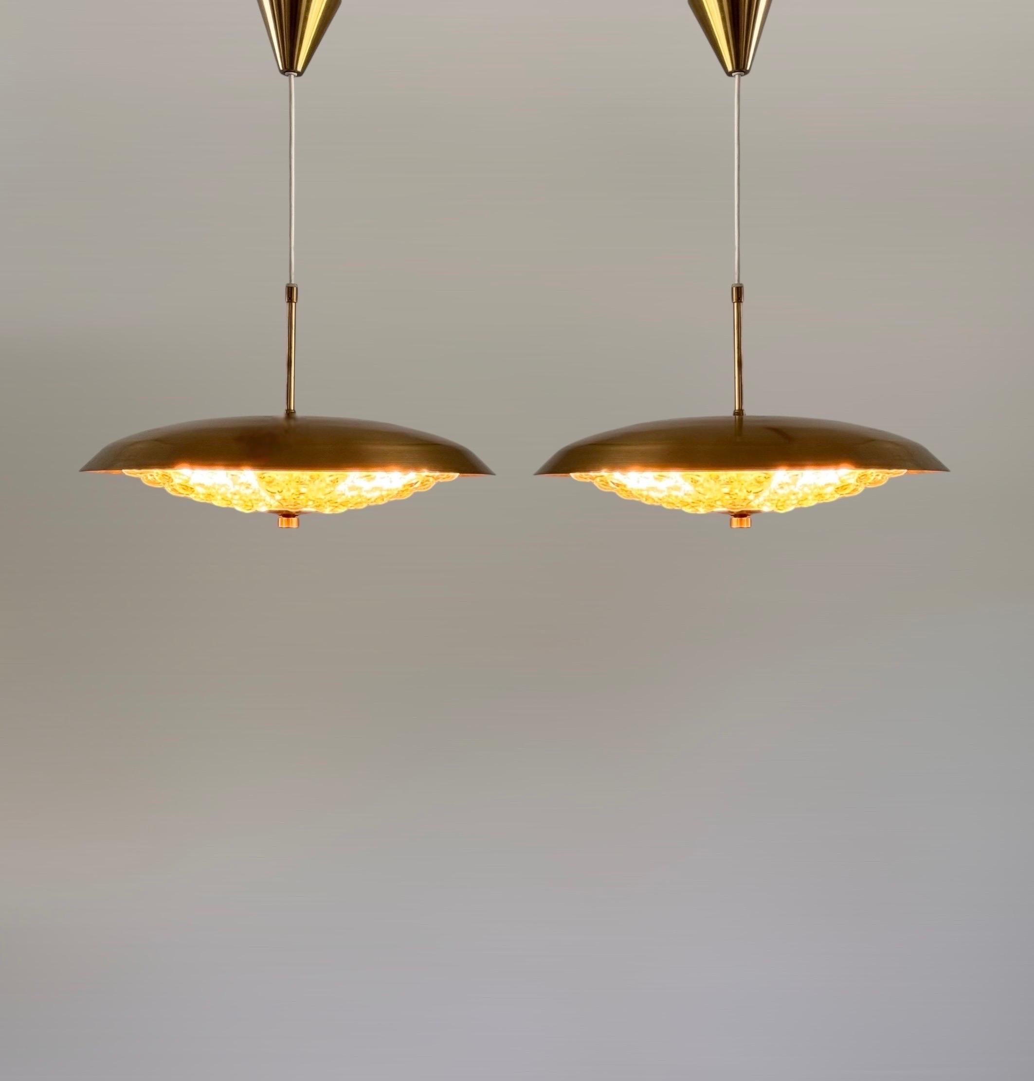 Questa bellissima coppia di lampadari a sospensione, disegnati dal famoso Carl Fagerlund per Lyfa negli anni '70, cattura l'essenza del design danese della metà del secolo scorso. I lampadari sono caratterizzati da un'impressionante combinazione di