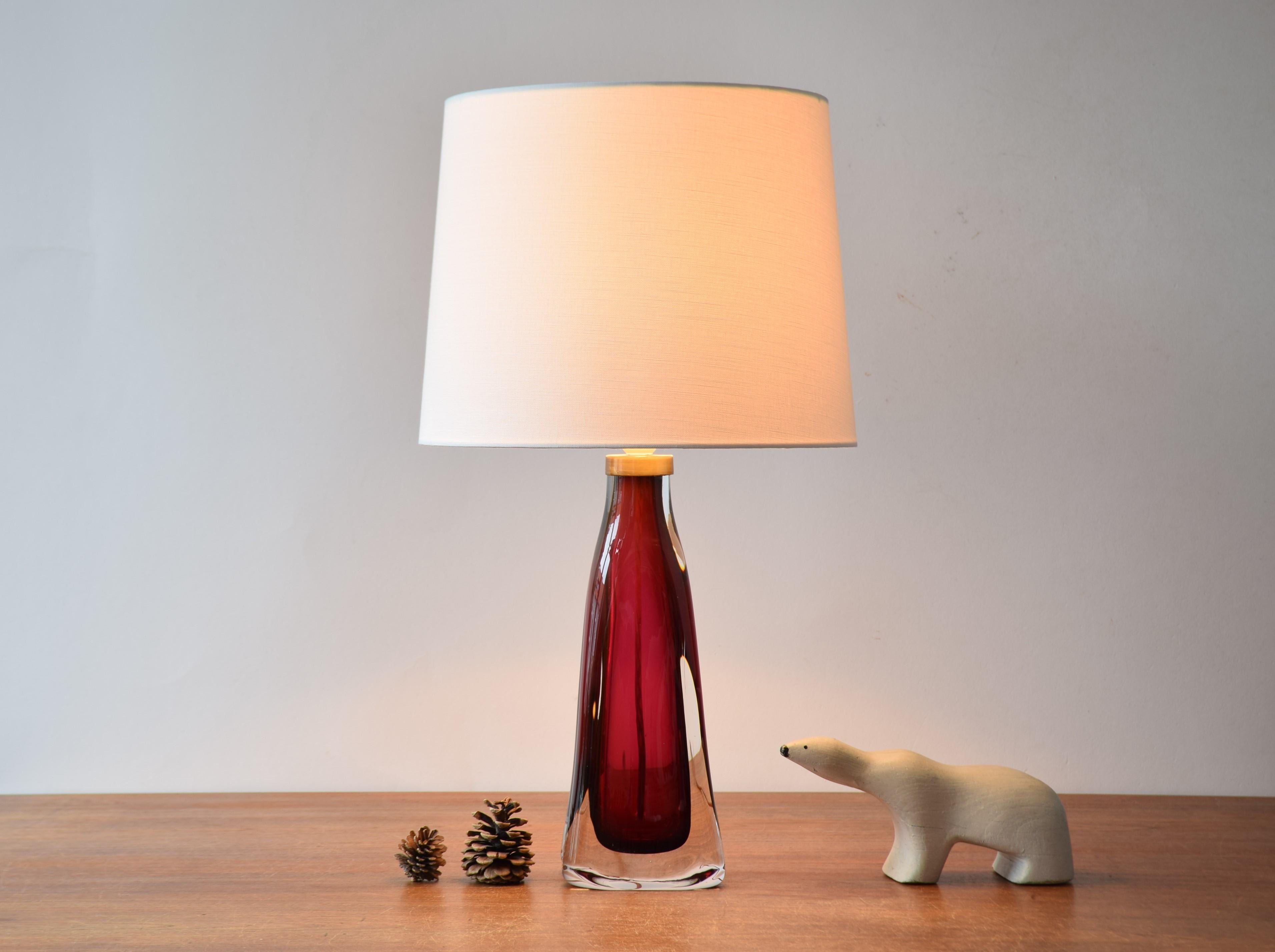 Tall mid-century crystal glass table lamp by Carl Fagerlund for Orrefors, Sweden. Made ca 1960s.

It has raspberry red and clear glass and a brass top. 

The lamp comes with a new lampshade designed and made in Denmark. It is made of woven