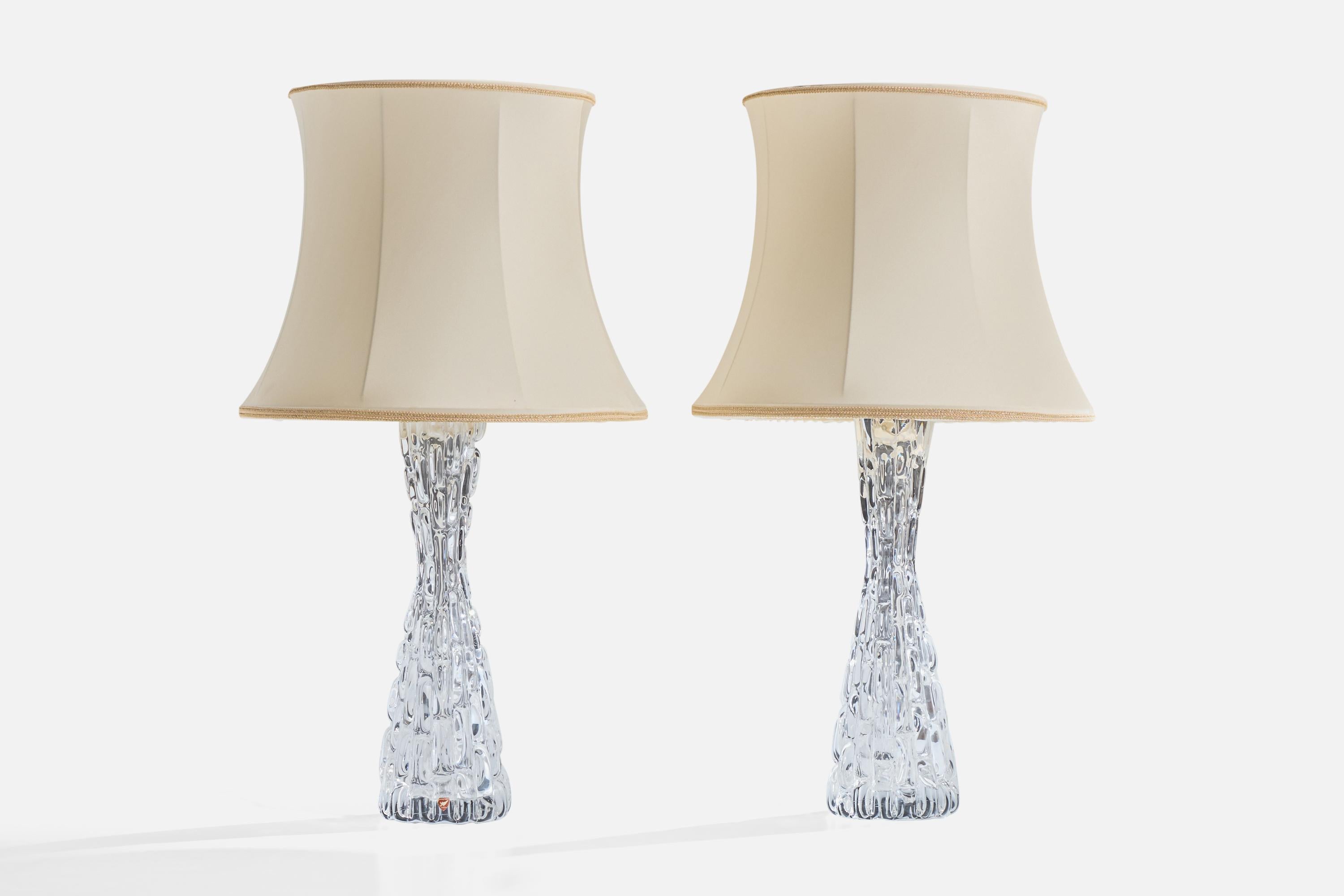 A pair of glass, metal and off-white fabric table lamps designed by Carl Fagerlund and produced by Orrefors, Sweden, c. 1950s.

Vintage fabric in fair condition.

Dimensions of Lamp with Shade (inches): 28.0