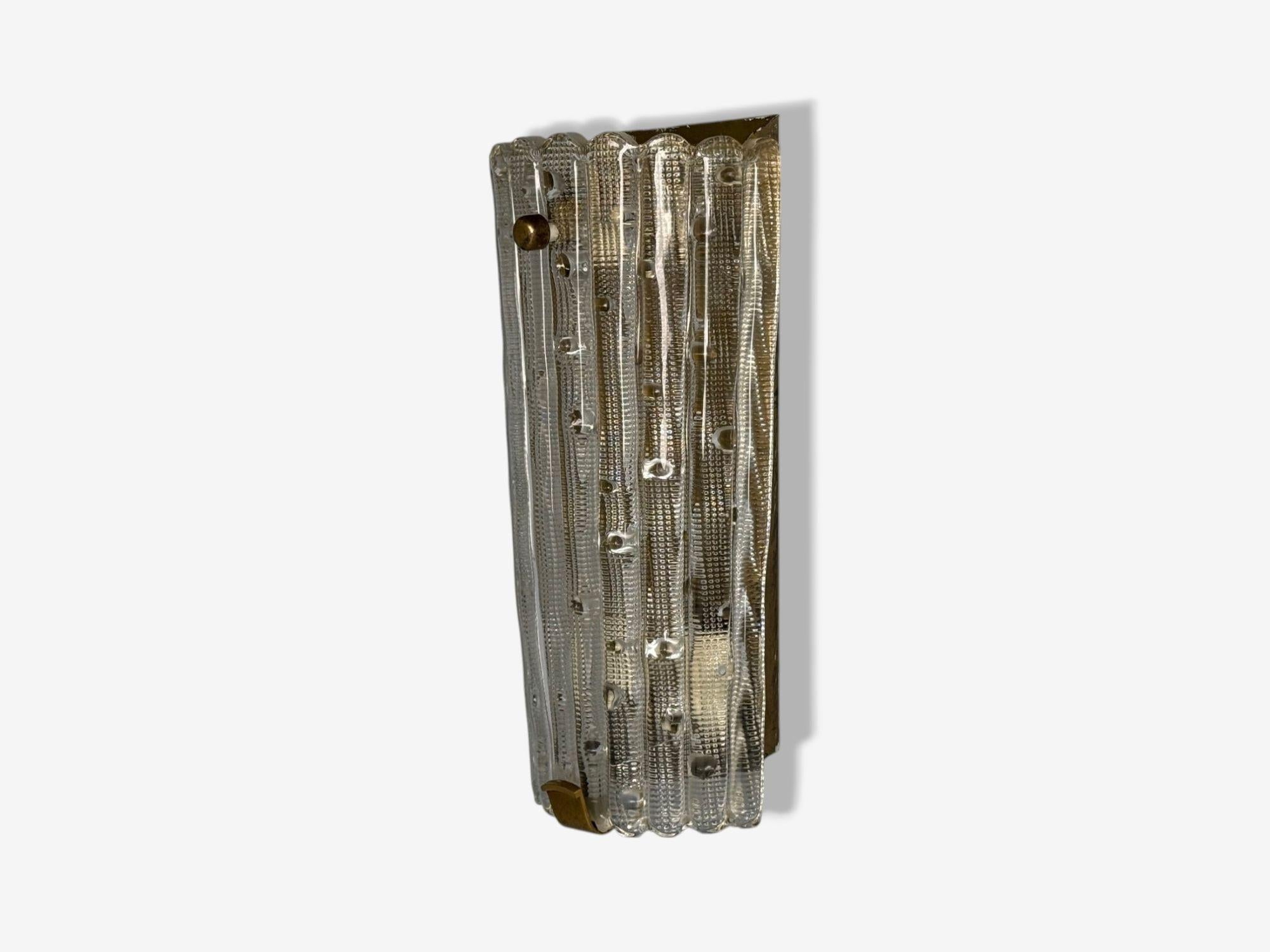Carl Fagerlund, Orrefors, Textured Glass, Brass, Large Wall Sconce, Sweden, 1940s

A large textured glass wall light on a brass back plate with brass detailing designed by Carl Fagerlund for Orrefors in Sweden c. 1940s. This fixture has three E27