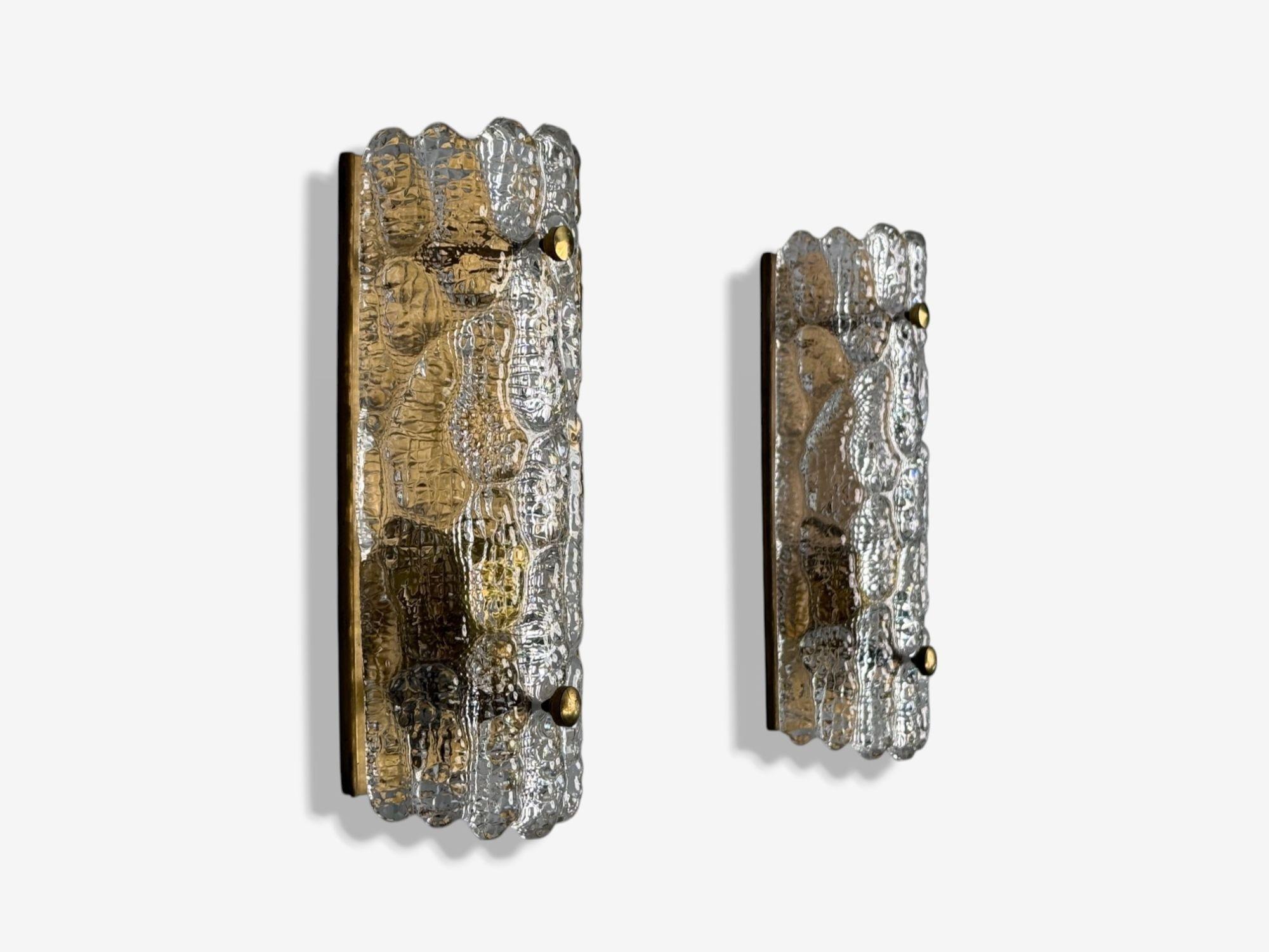 Carl Fagerlund, Textured Glass, Brass, Wall Lights, Sweden, 1960s

Pair of Swedish modern wall sconces designed by Carl Fagerlund for Orrefors in Sweden c. 1960s. Each example features a heavily textured piece of glass on a patinated brass