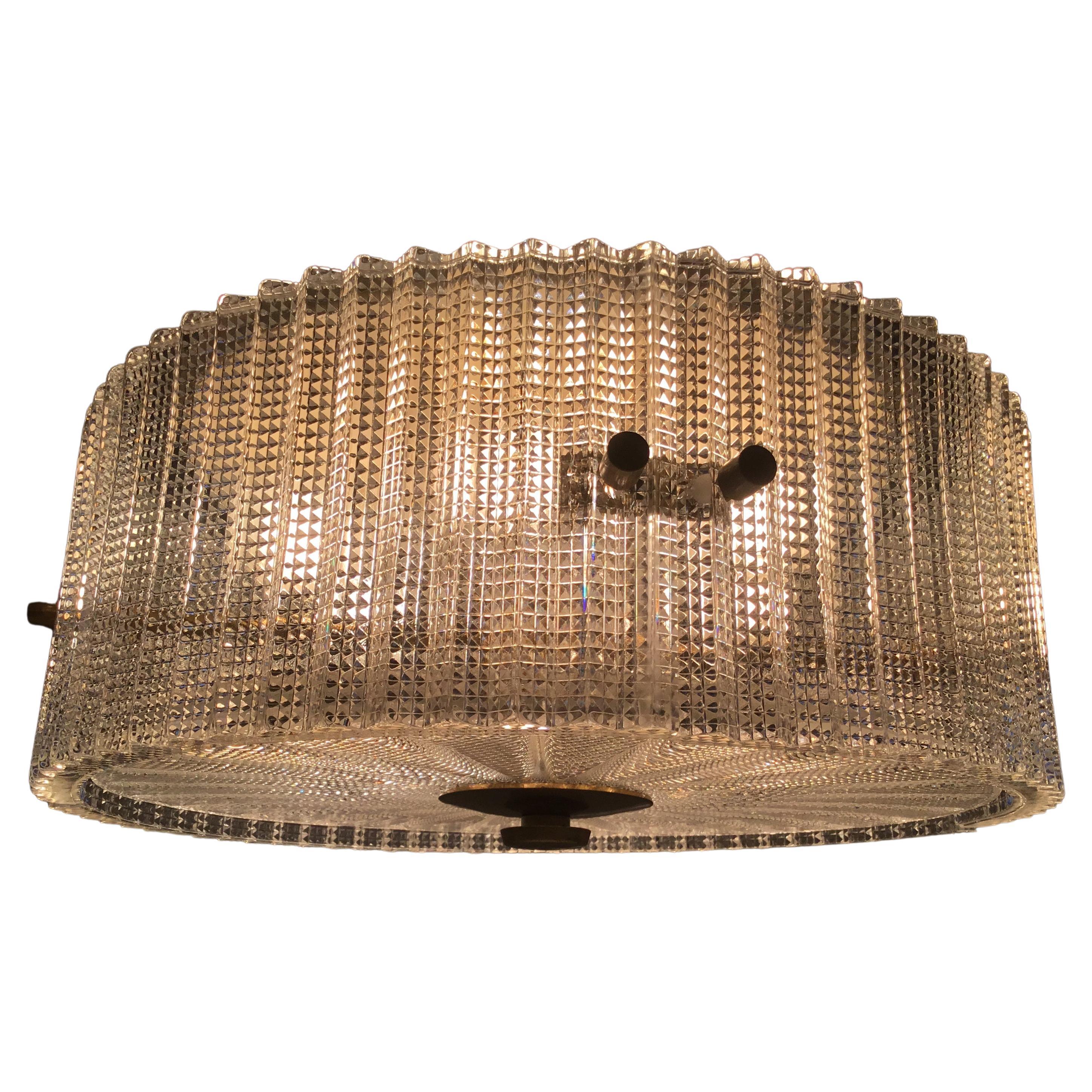 Large ceiling lamp Chandelier by the Swedish designer Carl Fagerlund for Orrefors, produced in the 1960s. 
The lamp is made of pressed translucent glass. The inside frame is made of brass and metal and it fitted with six sockets.
The ceiling lamp is