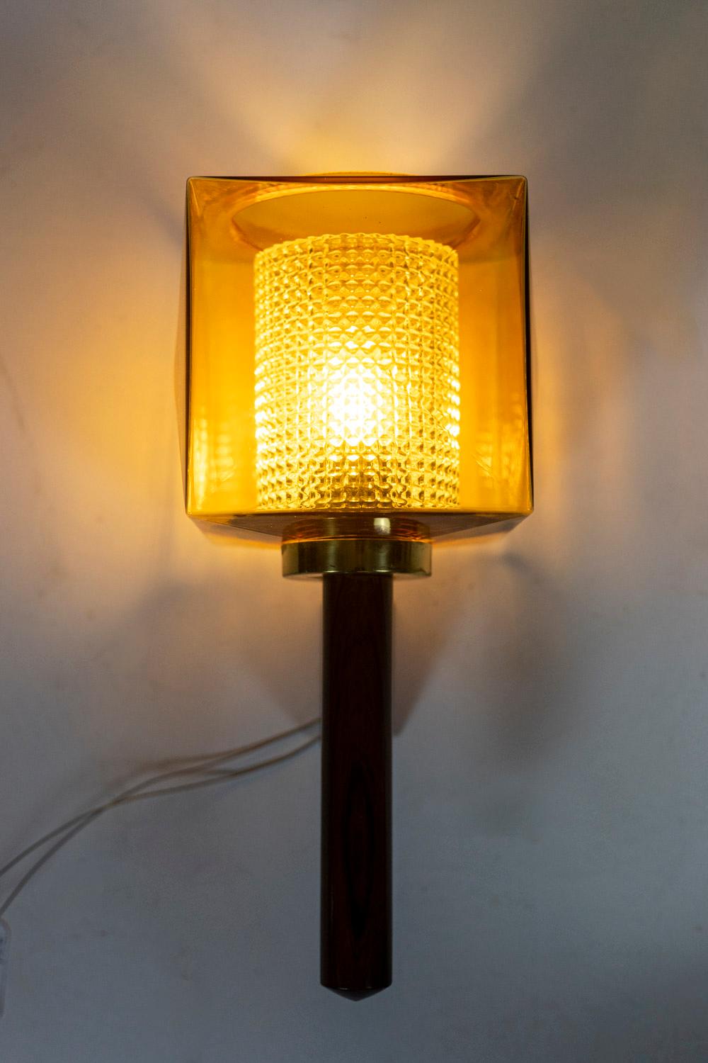 Carl Fagerlund, in the style of. 

Wall sconce in rosewood and glass, rectangular in shape. Granite glass, translucent and yellow in color.

Swedish work realized in the 1960s.

Dimensions : H 38 x W 18 x D 18 cm.