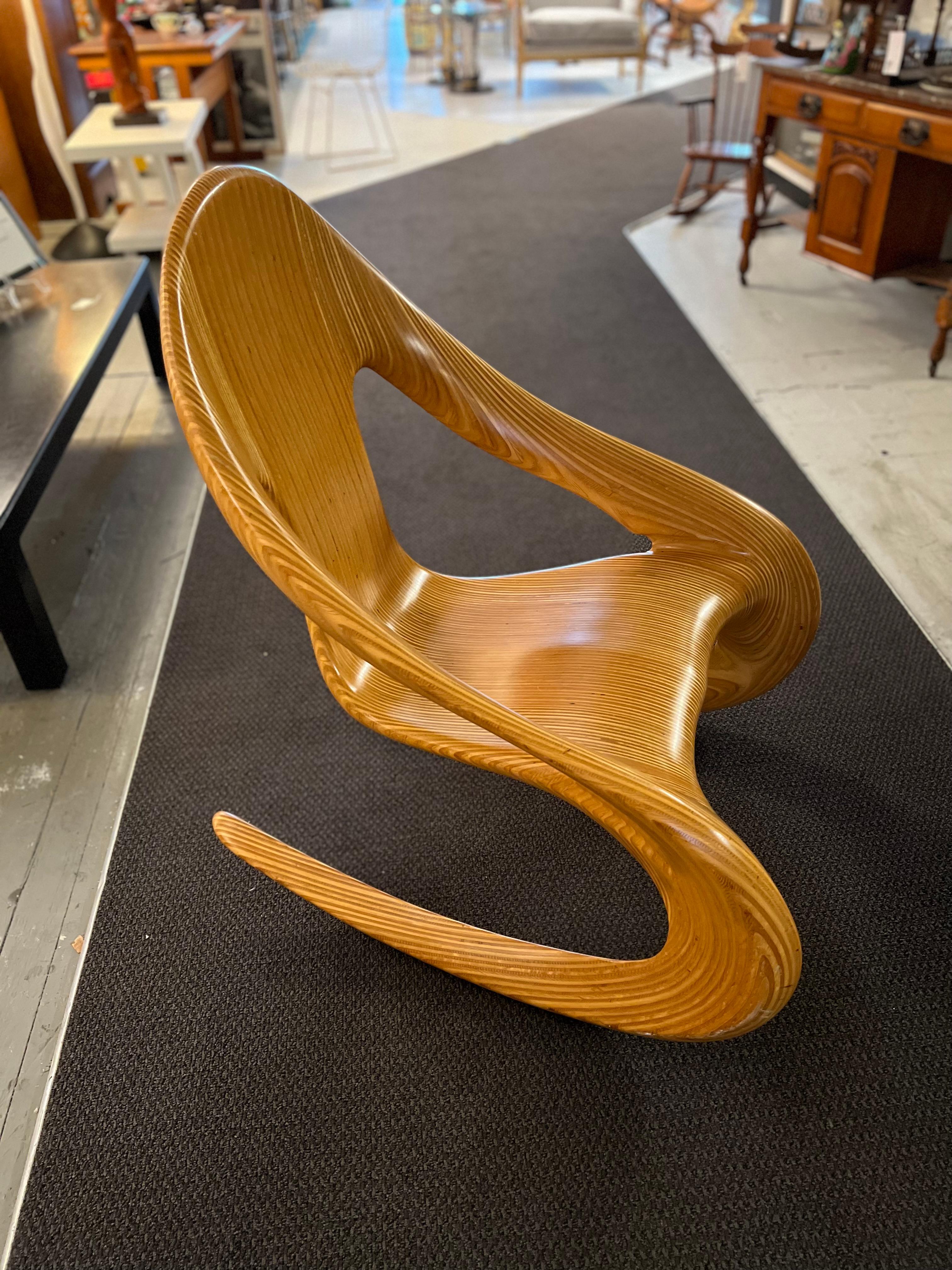 Unique by its incredible shape, wood use, and comfort, the rocker was made by Wisconsin woodworker Carl Gromoll (b. 1950). 
It is a statement piece!, signed and dated 1983 under the seat.
Handcrafted of stack-laminated, carved, and polished Baltic