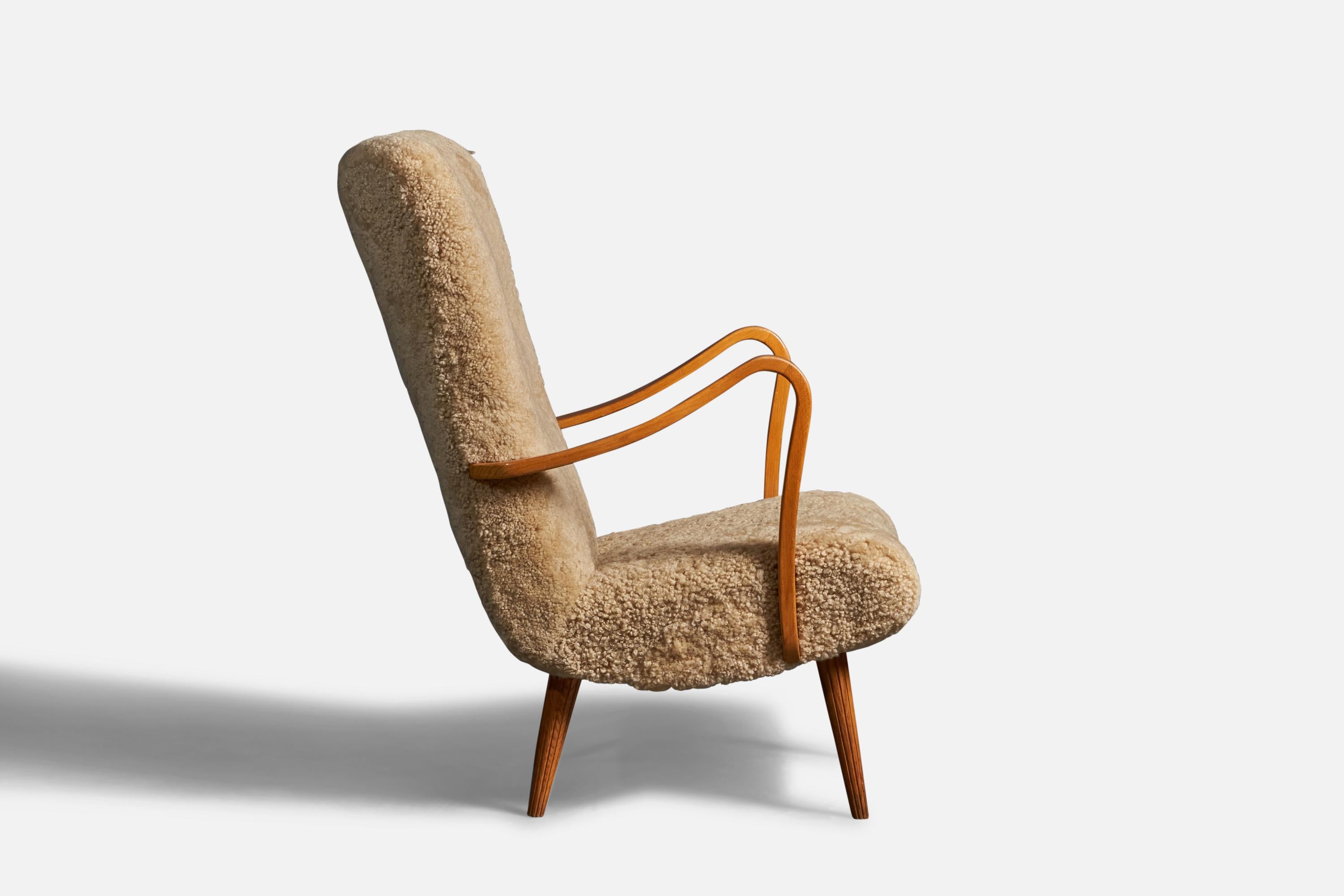 A wood and shearling lounge chair, design attributed to Carl Gustaf Hiort Af Ornäs, Finland, c. 1950s.

Seat height: 17