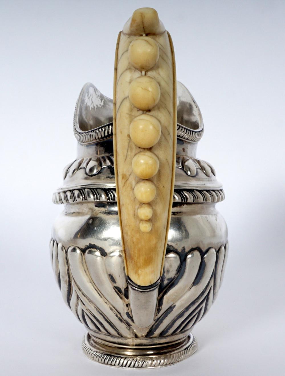 Open creamer, gadroom rim and base, embossed body with stylized foliate design, ivory handle, marked on base with mark of Carl Gustav Savay, 1829 assay mark. Overall 5.75