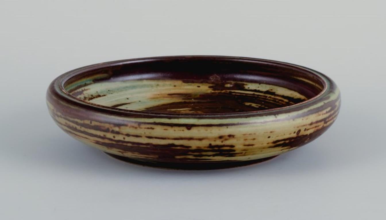 Carl Halier (1873-1948) for Royal Copenhagen, bowl in stoneware with sung glaze.
Model number 21822.
Marked.
First factory quality.
Dimensions: D 15.5 x H 3.5 cm.