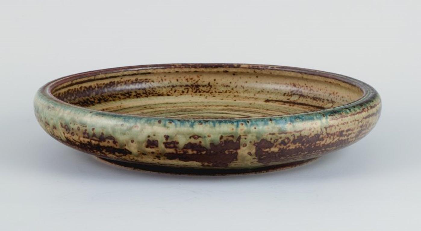 Carl Halier for Royal Copenhagen, bowl in stoneware with sung glaze.
Model number 21824.
Marked.
First factory quality.
Dimensions: D 24.0 x H 4.5 cm.