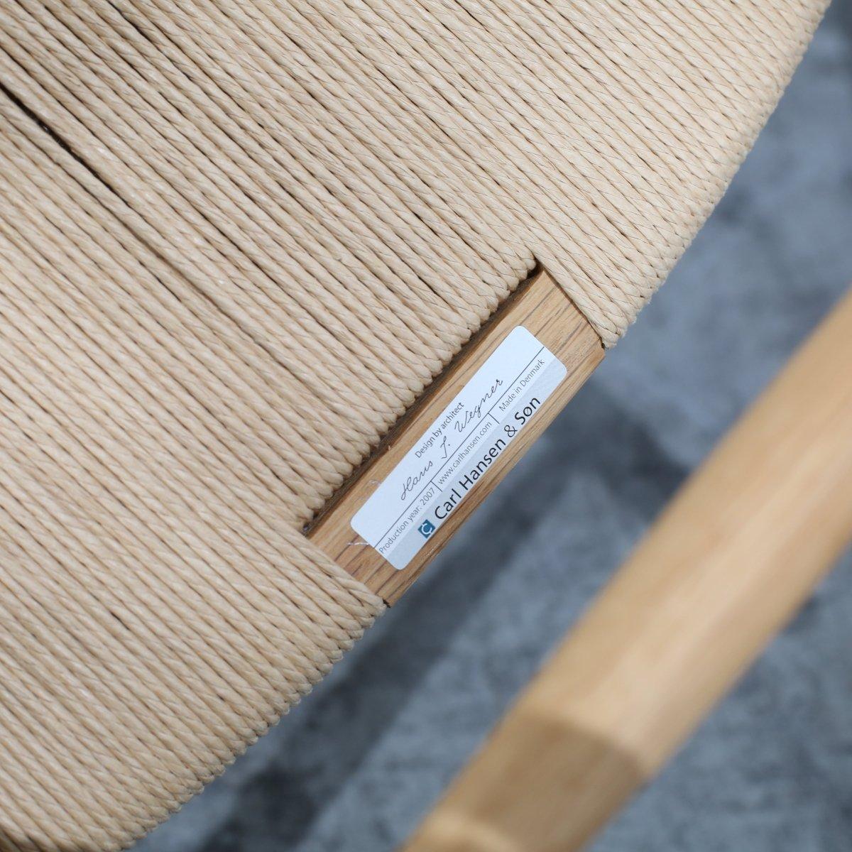 The CH24 Wishbone Chair by Hans J. Wegner for Carl Hansen & Son is an enduring icon of Scandinavian design. Defined by its elegant curved backrest and distinctive wishbone-shaped frame, it is expertly crafted from solid wood for lasting strength and