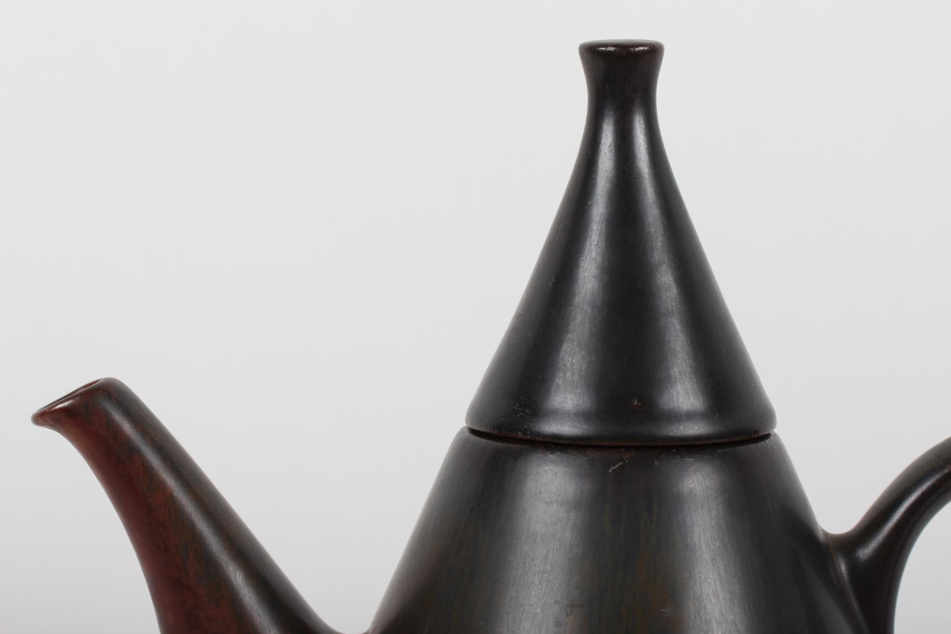Rare and very special conical formed ceramic teapot is designed by the famous Swedish ceramist Carl-Harry Staalhane (1920-1990) and manufactured by Rörstrand Sweden

The teapot is decorated with dark red-brown glaze
Signed Rörstrand Sweden,