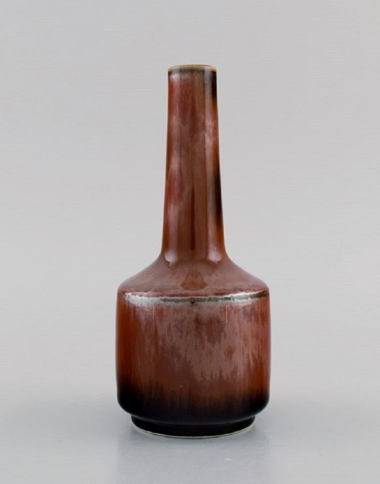 Carl Harry Stålhane (1920-1990) for Rörstrand. Narrow neck vase in glazed ceramics. Beautiful metallic glaze in reddish-brown shades. Mid-20th century.
Measures: 15 x 6.5 cm.
In excellent condition.
Stamped.
1st factory quality.