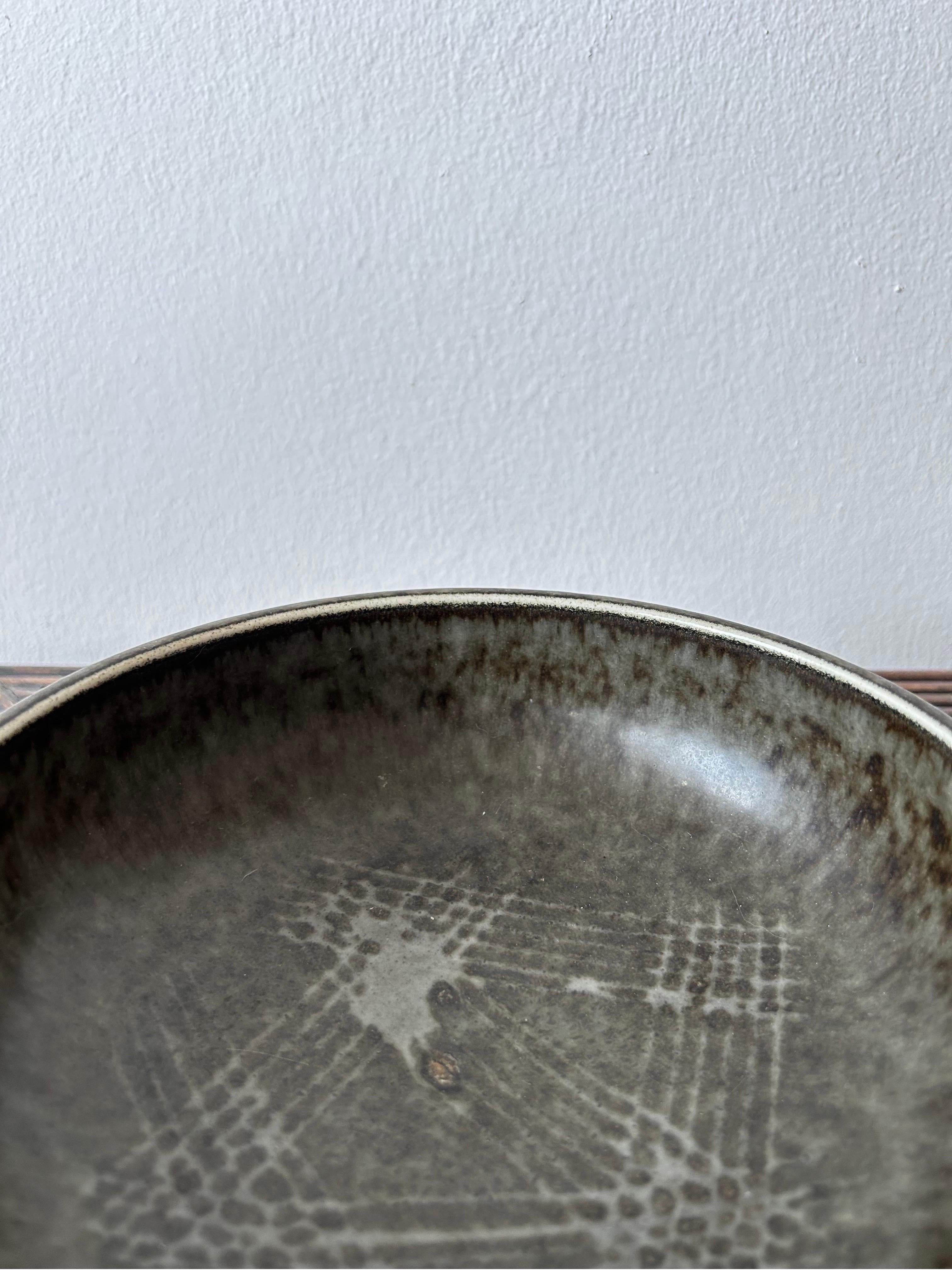 Beautiful ceramic bowl by Swedish artist Carl Harry Stålhane made at Rörstrand atelje in the 1950’s.

The bowl has a beautiful glaze which gives a beautiful structure to the bowl.
The glaze is a mixture of dark gray, brown and black which is a