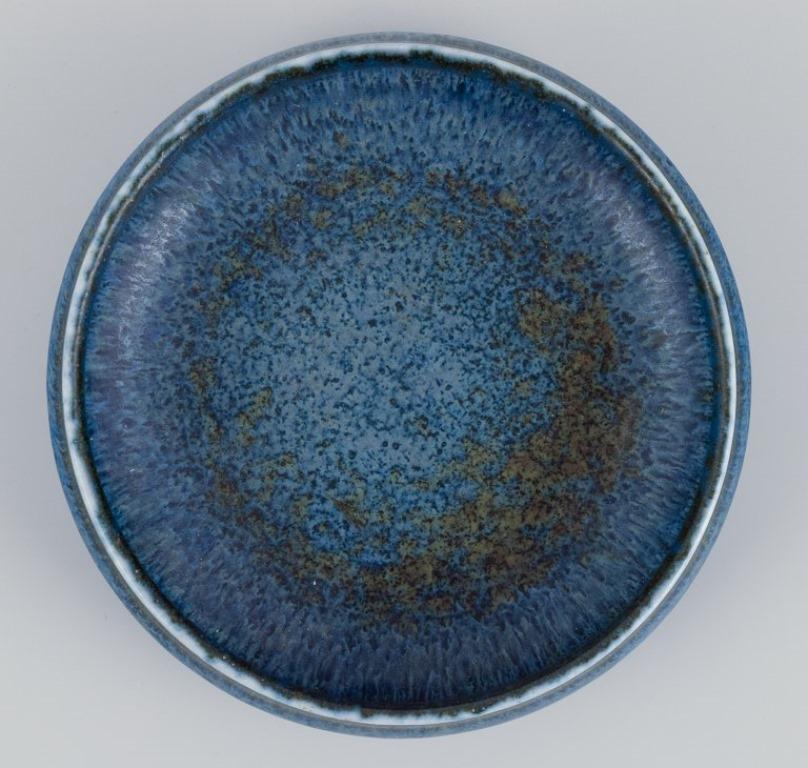 Carl Harry Stålhane (1920-1990) for Rörstrand. 
Ceramic bowl with blue-toned glaze.
Mid-20th century.
Marked.
In excellent condition with a minor chip in the base.
Second factory quality.
Dimensions: Diameter 13.3 cm x Height 3.5 cm.