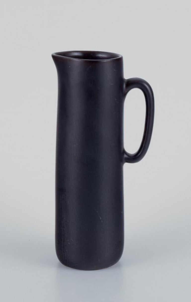 Carl Harry Stålhane for Rörstrand.
Ceramic jug with glaze in dark brown shades.
Mid-20th century.
Marked.
In very good condition with minor wear.
First factory quality.
Dimensions: H 16.5 x D 7.3 cm including handle.

