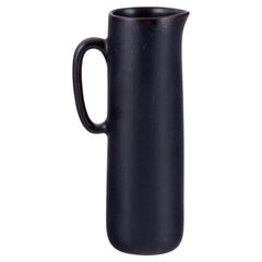 Carl Harry Stålhane for Rörstrand. Ceramic jug with glaze in dark brown shades. 