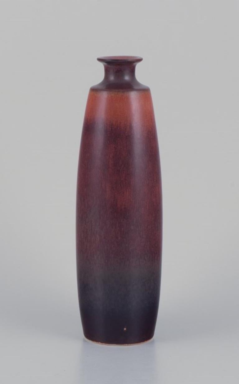 Carl Harry Stålhane (1920-1990) for Rörstrand. 
Ceramic vase with glaze in brown shades.
Mid-20th century.
Marked.
Perfect condition.
First factory quality.
Dimensions: D 8.0 cm x H 27.0 cm.

Carl-Harry Stålhane is widely recognized as a prominent