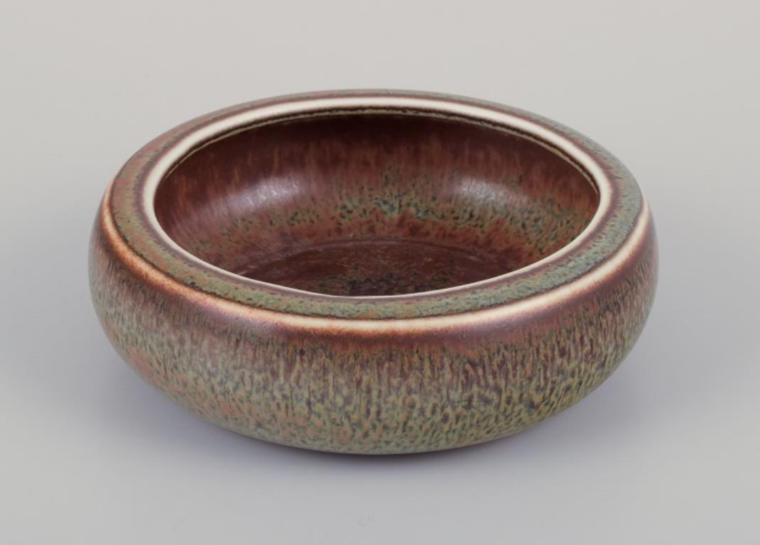 Carl Harry Stålhane (1920-1990) for Rörstrand. 
Low ceramic bowl with brown and green glaze.
Mid-20th century.
Marked.
In perfect condition.
First factory quality.
Dimensions: D 12.0 cm x H 4.0 cm.

Carl-Harry Stålhane is widely recognized as a
