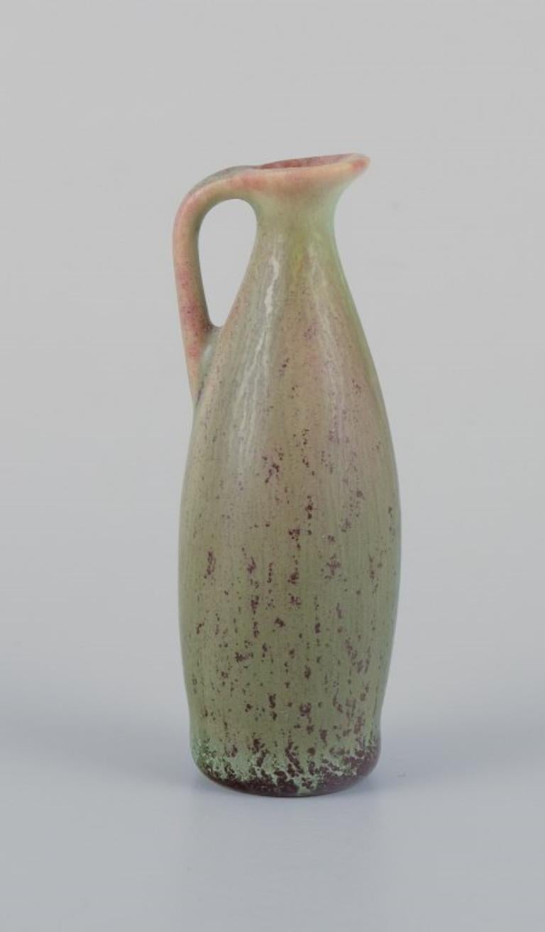Carl-Harry Stålhane for Rörstrand, miniature jug/vase with glaze in green-brown hues.
Mid-20th century.
Marked.
In perfect condition.
First factory quality.
Dimensions: H 72 mm x D 25 mm.