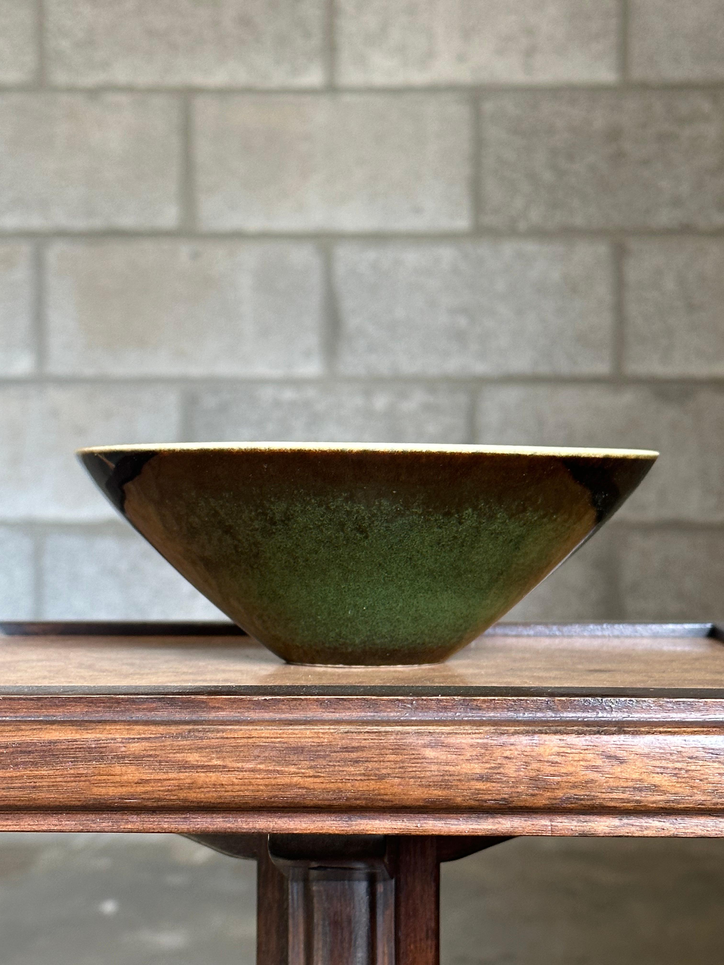 A charming bowl designed by Carl Harry Stålhane for Rörstrand. Bowl features an emerald green body with a yellowish/gold rim. A very attractive color and shape.