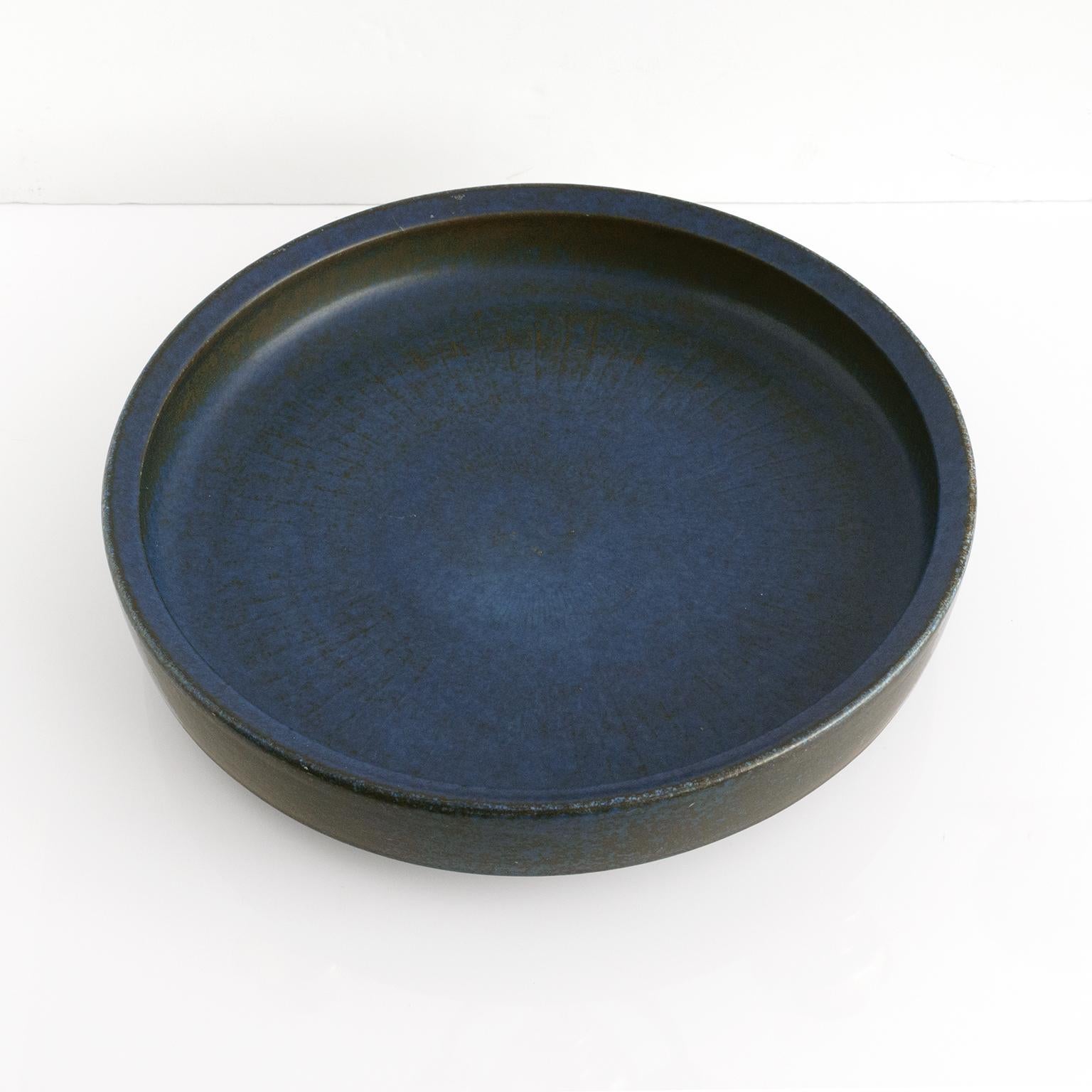 A large Carl-Harry Stålhane blue glazed ceramic bowl with subtle radiating lines on the inside. Hand thrown by Stålhane at the Rorstrand Ateljé circa 1960’s. Signed on the bottom. 

Measures: Diameter: 15.25”, height: 3”.