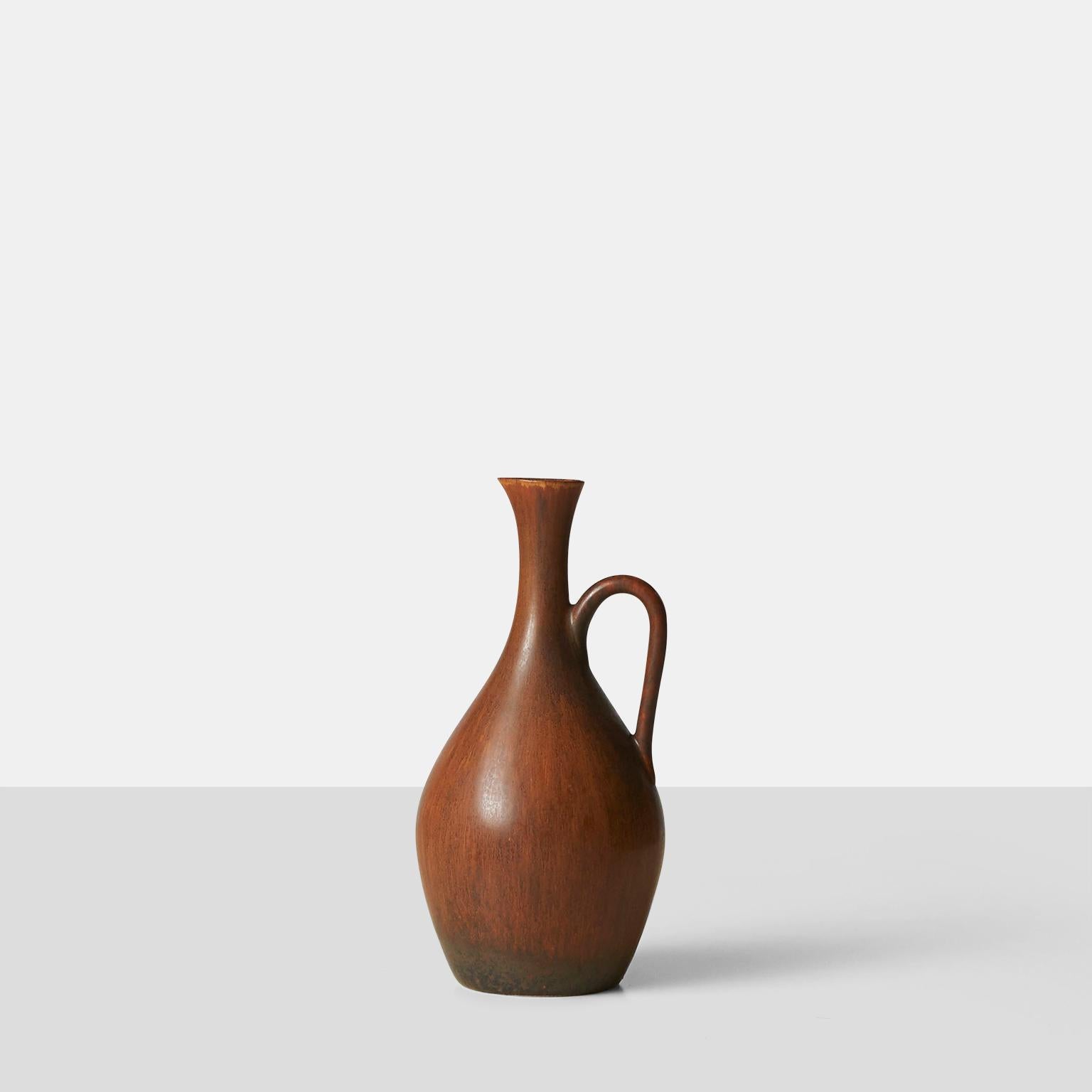 A cinnamon colored stoneware water jug for Rorstrand. Inscribed on base with makers initials and studio mark.