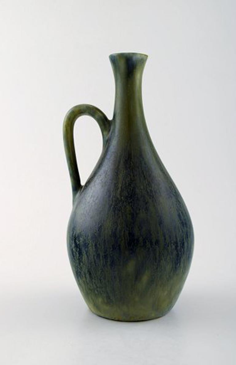 Carl Harry Stålhane, Rörstrand bottle vase with handle in stoneware.
Beautiful glaze in blue-green shades, mid-20 century.
In perfect condition.
Measures: 16 cm x 8 cm.
Marked.
