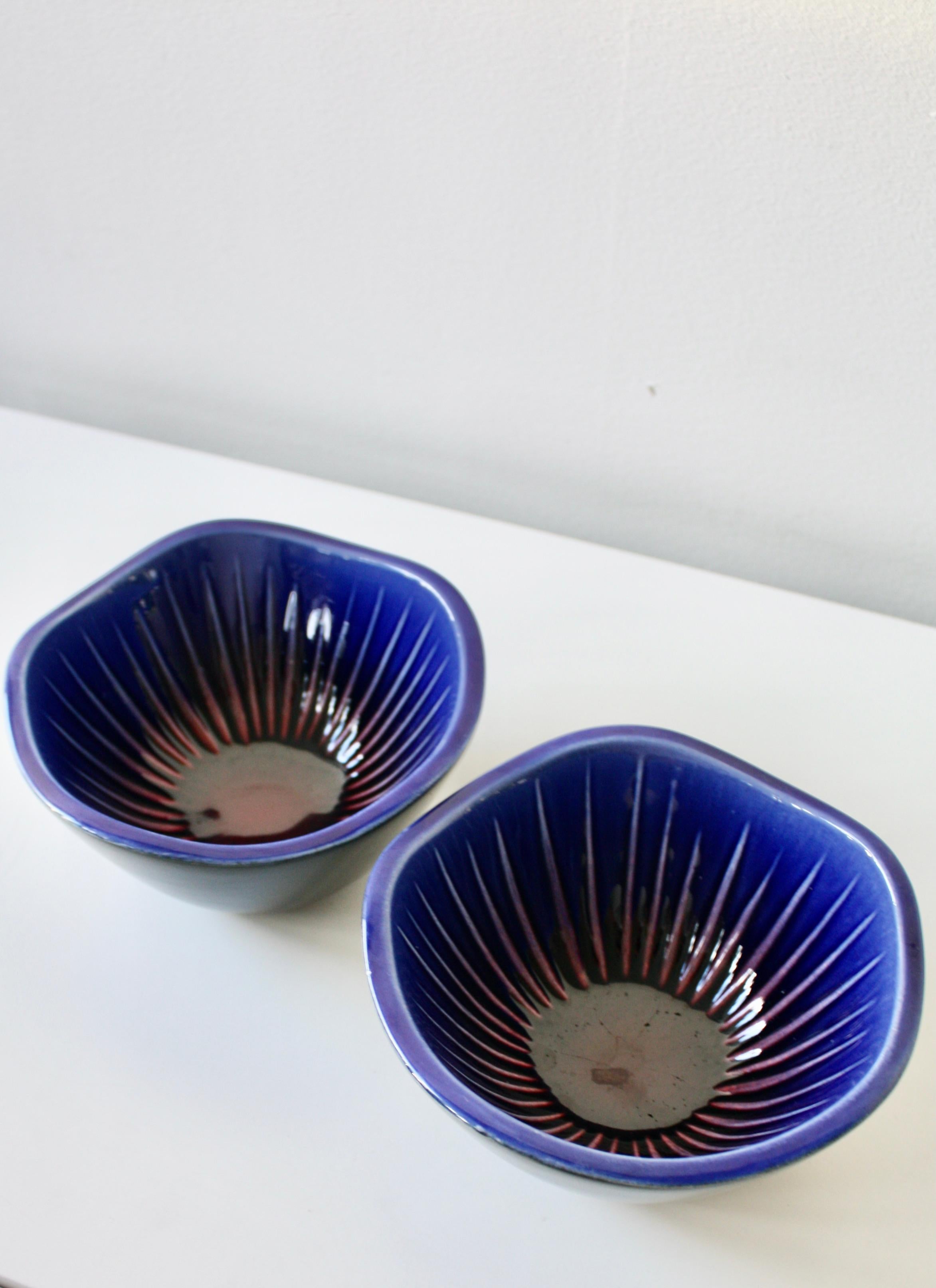 Two amazing bowls, Sparaxis Anemone by Carl-Harry Stålhane for Rörstrand, Sweden ca 1950-1960s.
The bowls are black on the outside, with a beautiful inside in cobalt blue along with a deep red color in the middle. The colors, together with the wavy