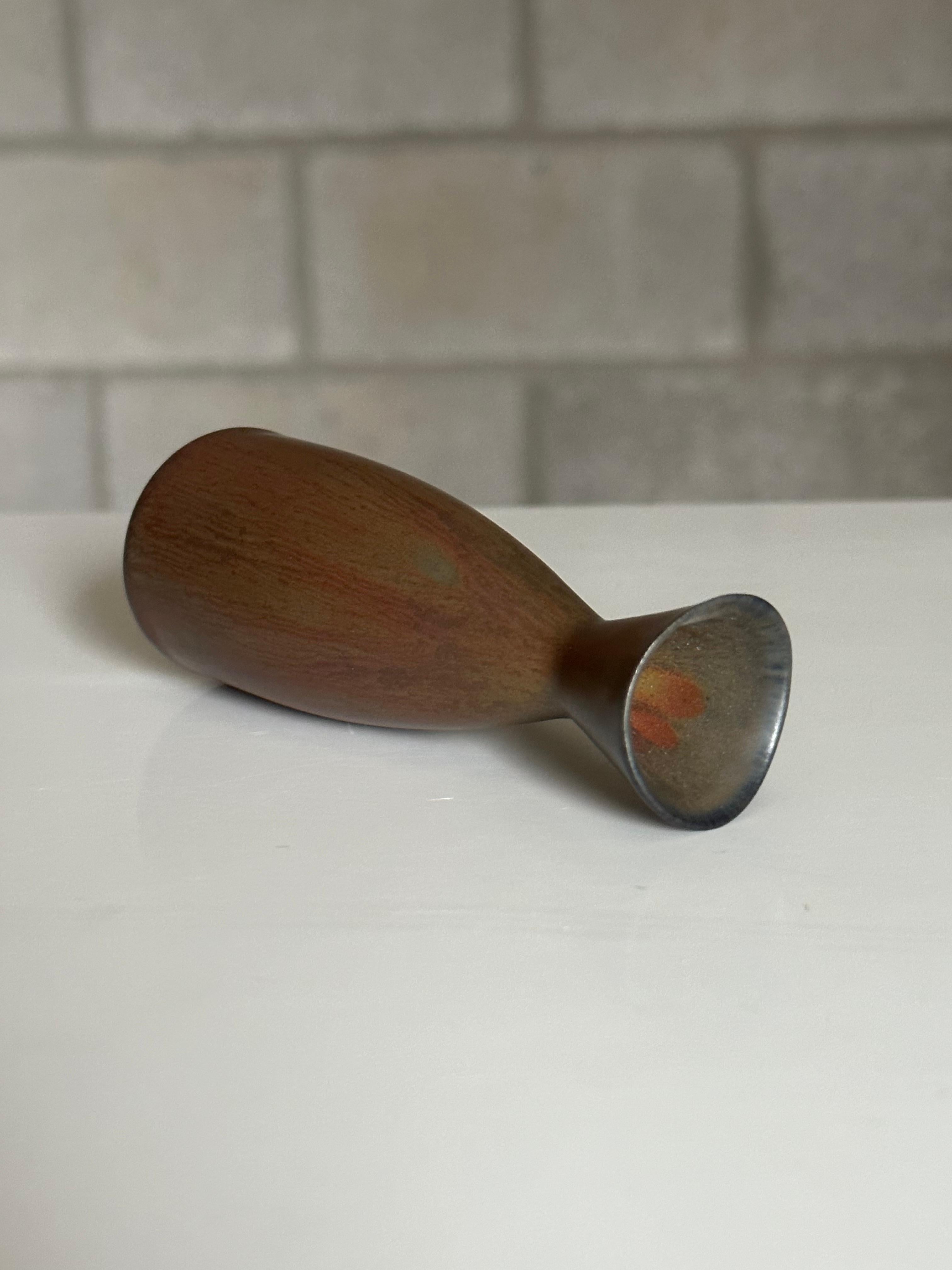 A small vase designed by Carl-Harry Stålhane. A great addition to any collection, this vase has earth tones ranging from a rust/ terra cotta to a slate/brown. In very good condition.